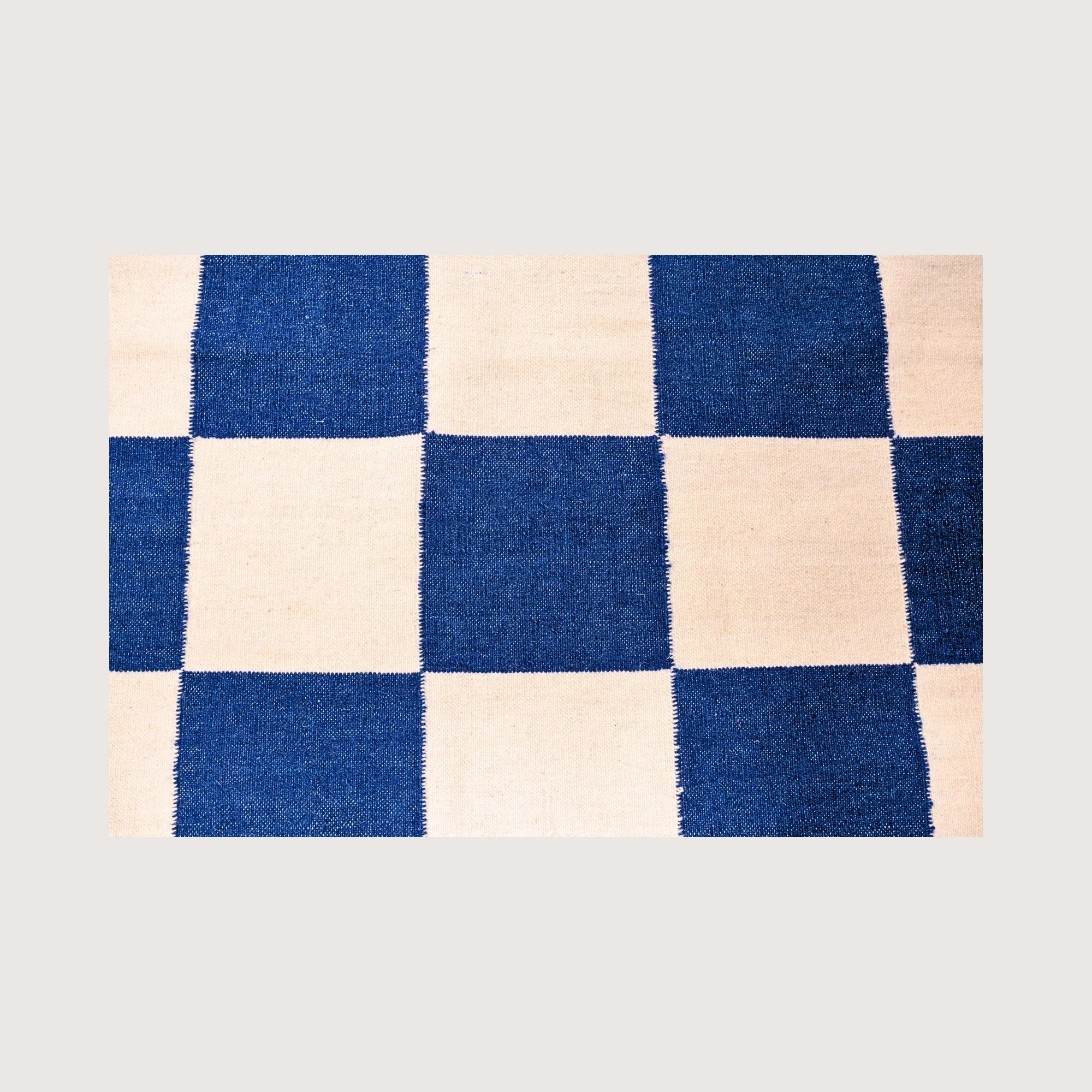 Close-up of Khana Neel rug showing handwoven texture and checkered pattern