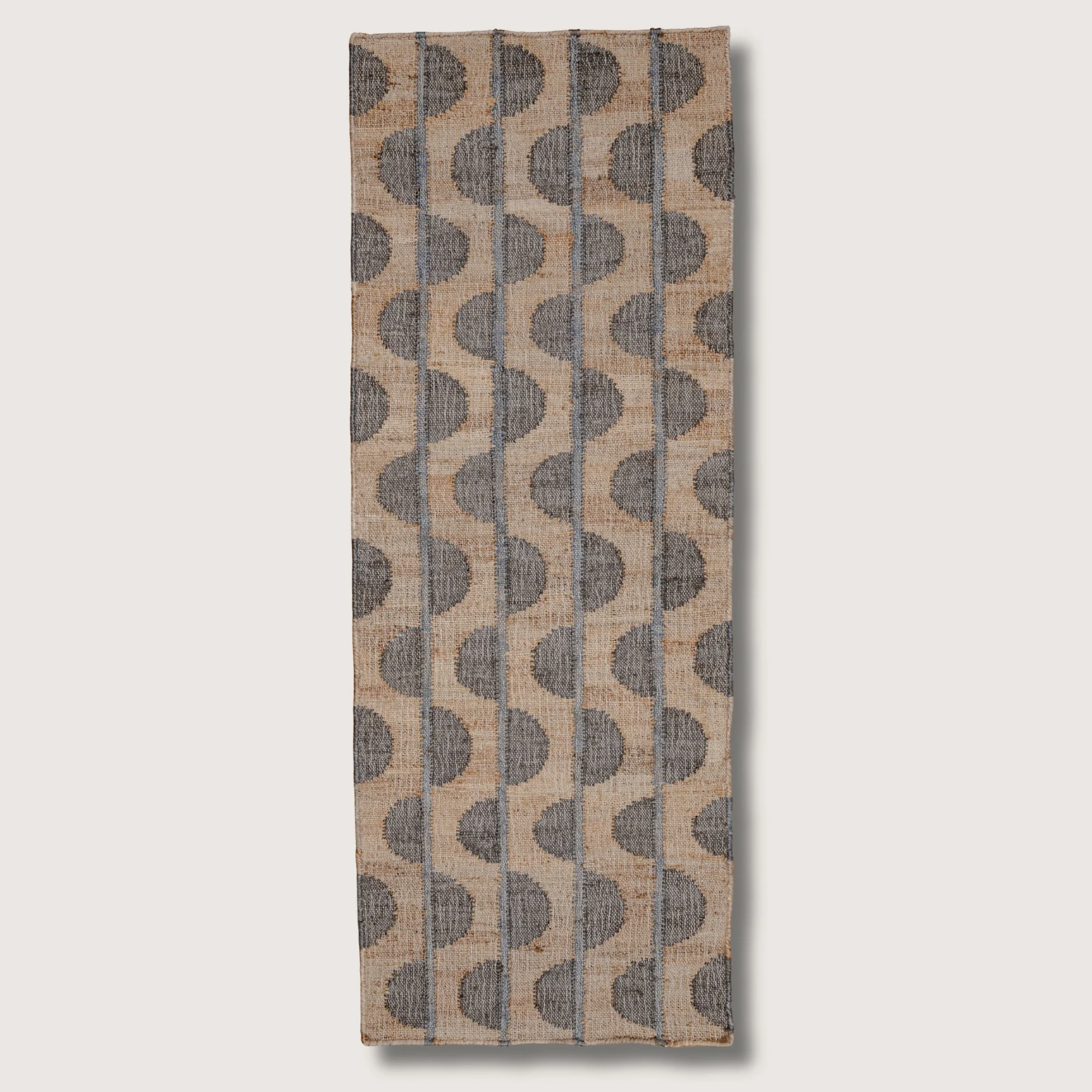 Handwoven jute runner with repeating half-moon pattern in muted zaitun and natural sand tones with fine slate-grey detailing.