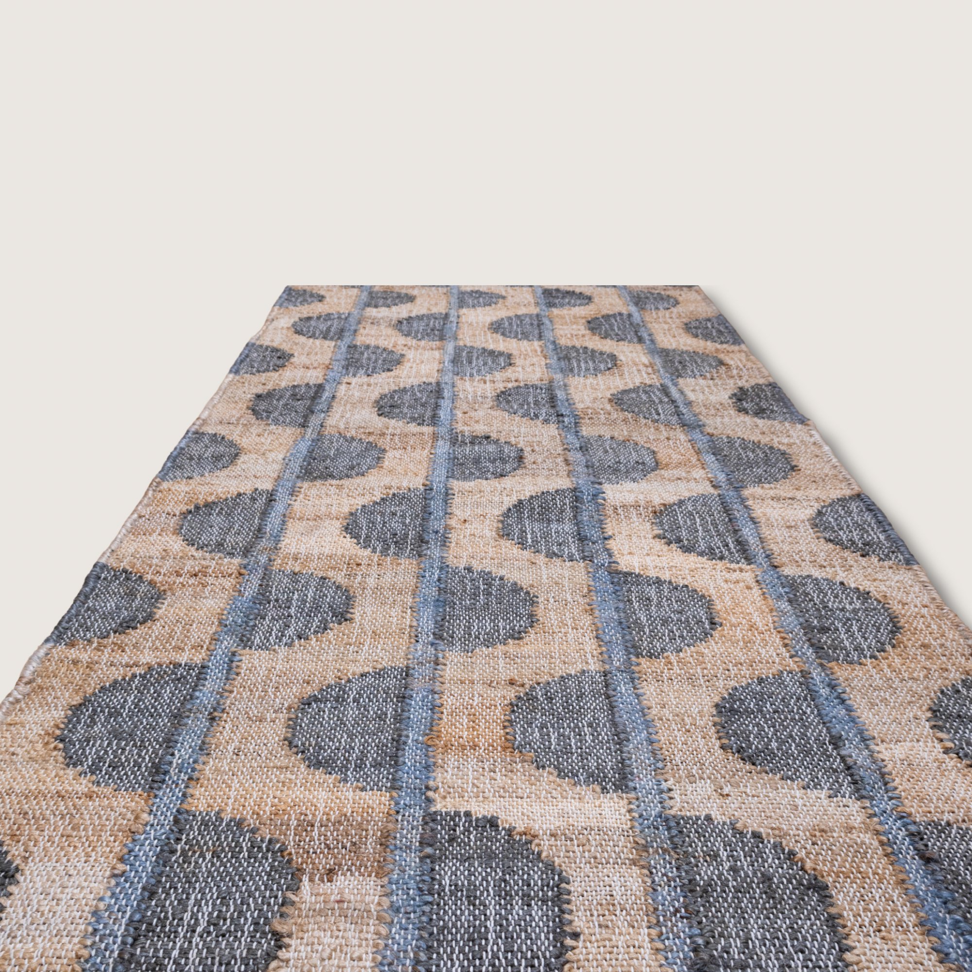 Handwoven jute runner with repeating half-moon pattern in muted zaitun and natural sand tones with fine slate-grey detailing.