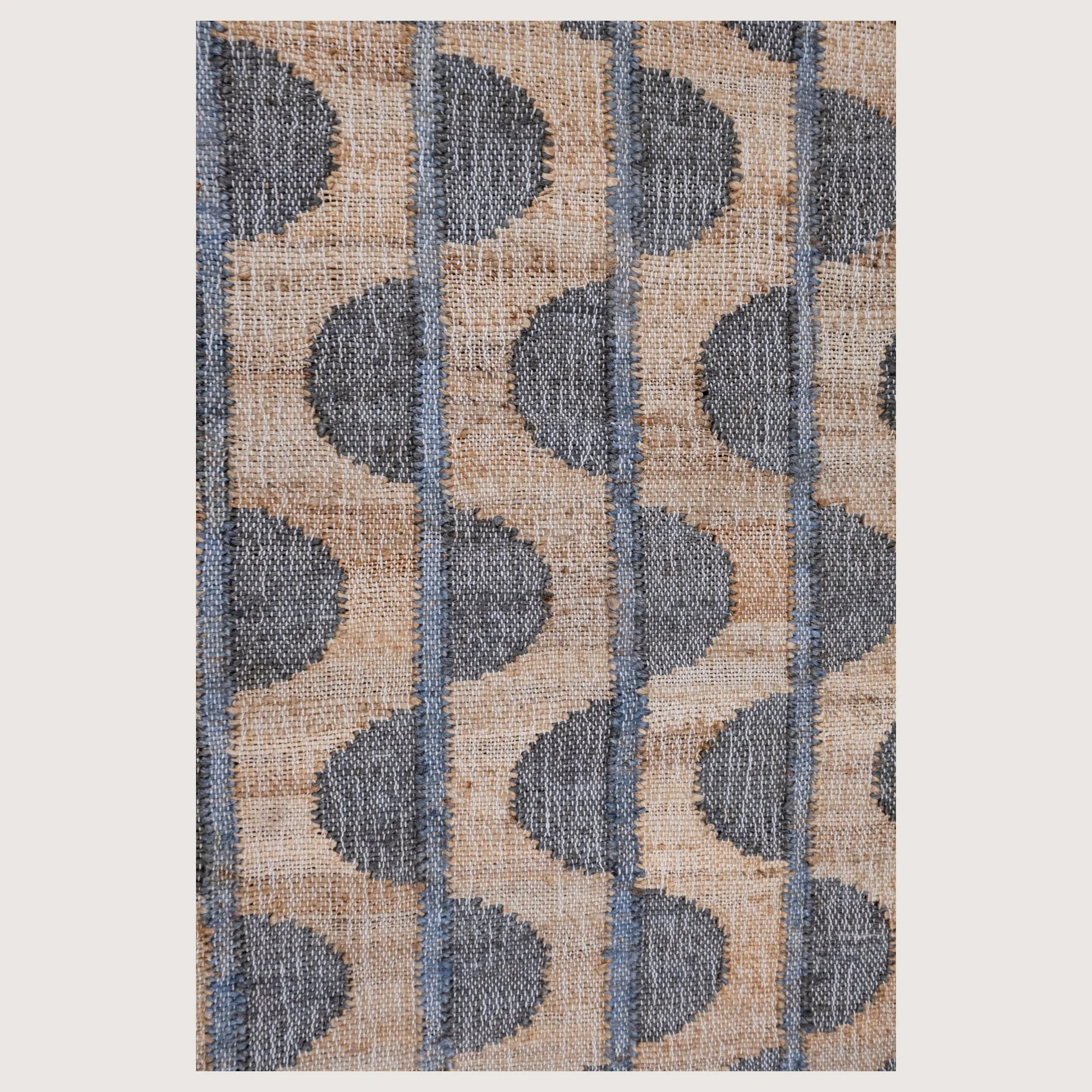 Handwoven jute runner with repeating half-moon pattern in muted zaitun and natural sand tones with fine slate-grey detailing.