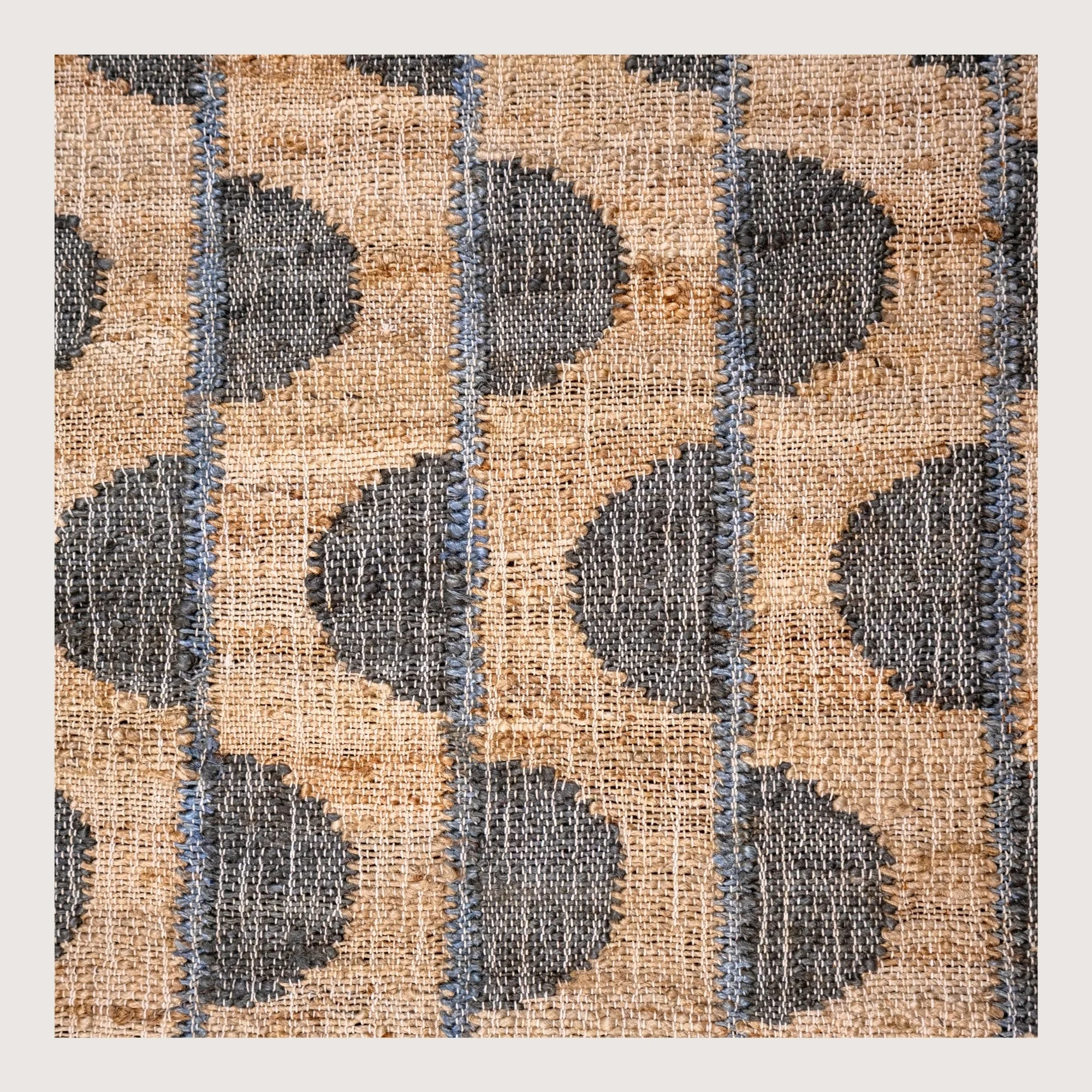Handwoven jute rug with repeating half-moon pattern in muted zaitun and natural sand tones.