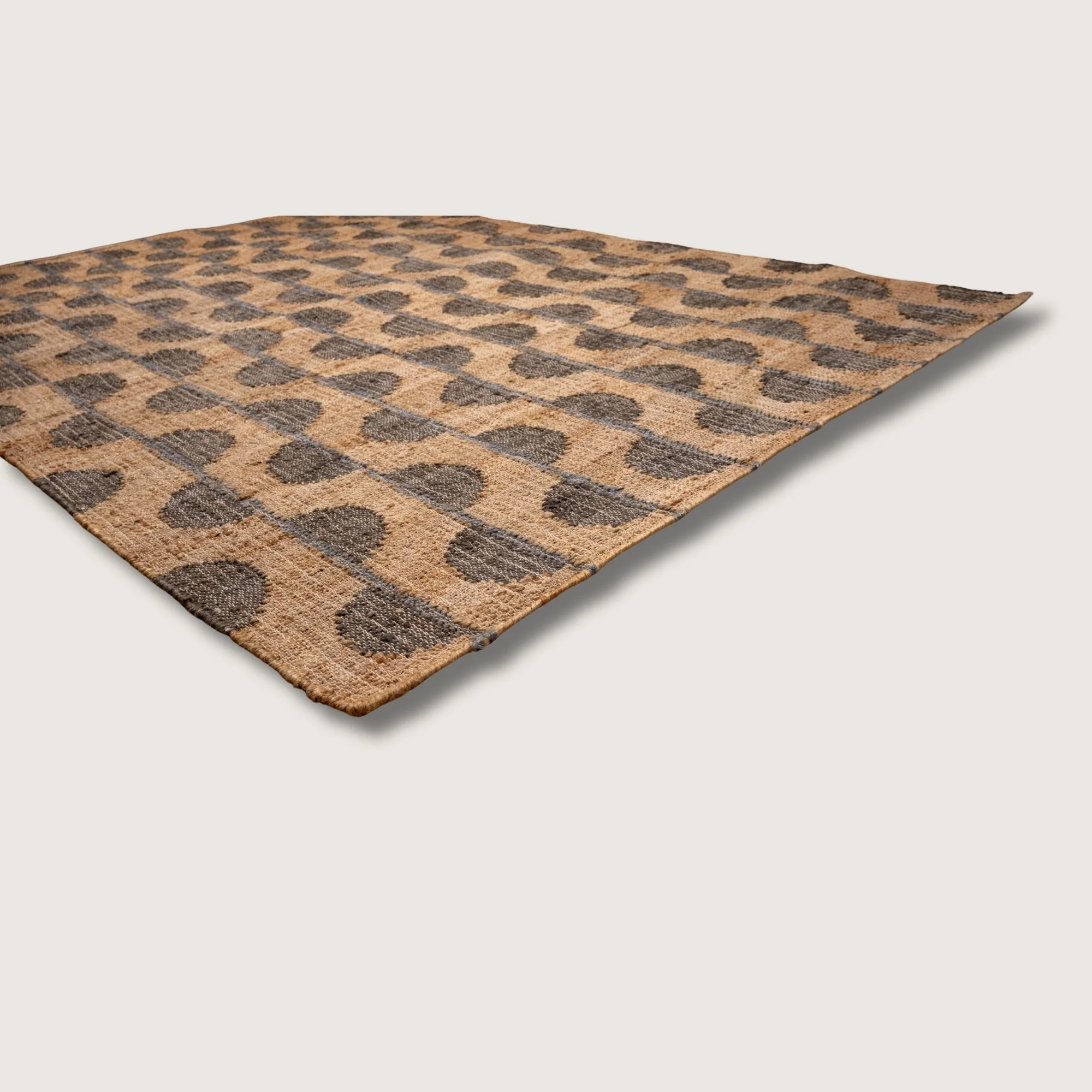 Handwoven jute rug with repeating half-moon pattern in muted zaitun and natural sand tones.