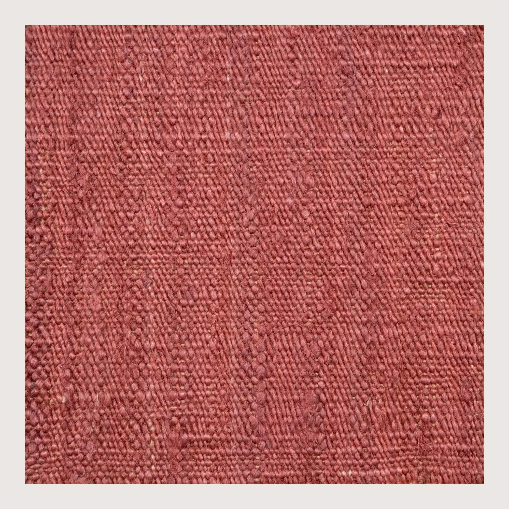 Plain handwoven jute rug in soft dusty gulabi tones with subtle natural texture.