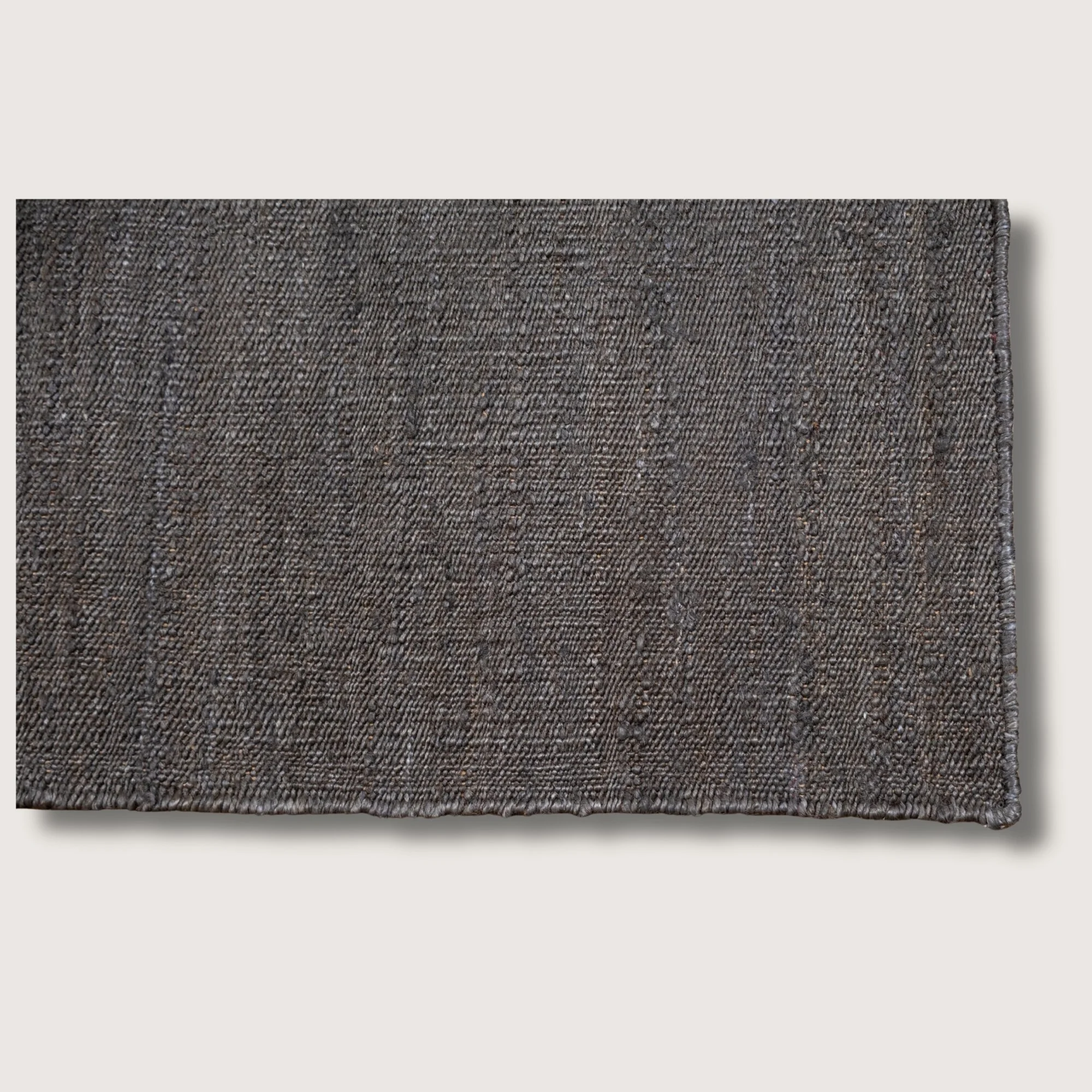 Plain handwoven jute rug in muted zaitun tones with subtle natural texture.