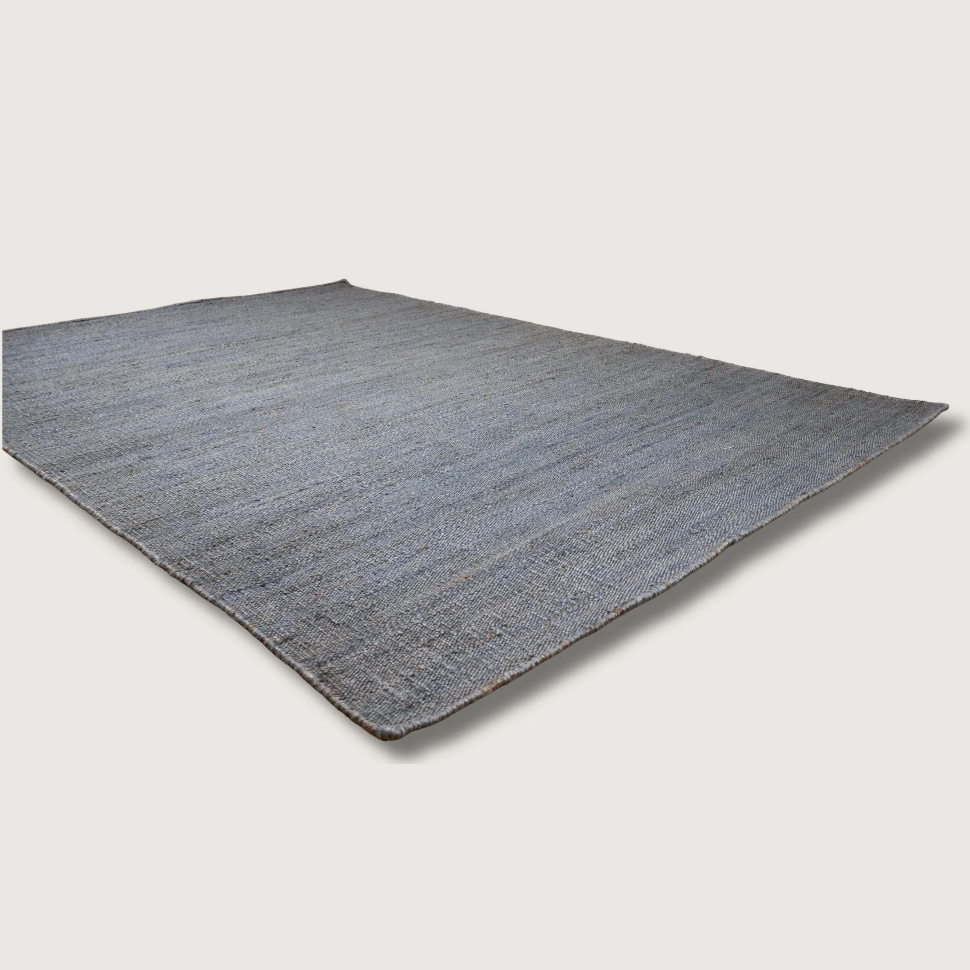 Plain handwoven jute rug in muted neel tones with subtle natural texture.