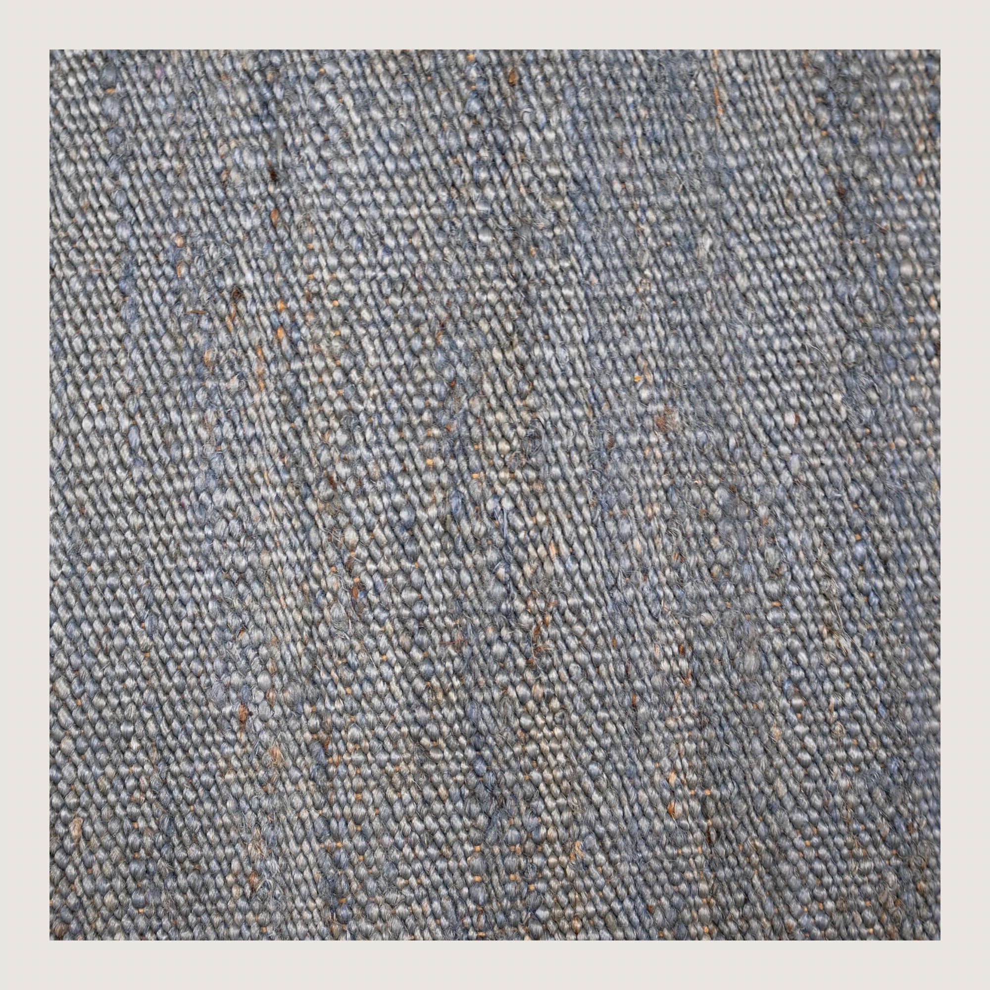 Plain handwoven jute rug in muted neel tones with subtle natural texture.
