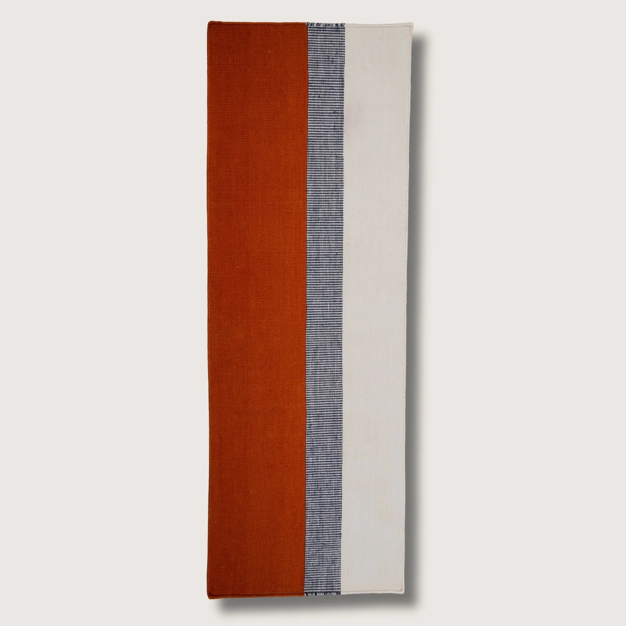 Handwoven wool flatweave runner with color block design in Bombay, deep neel, and whisper white tones.