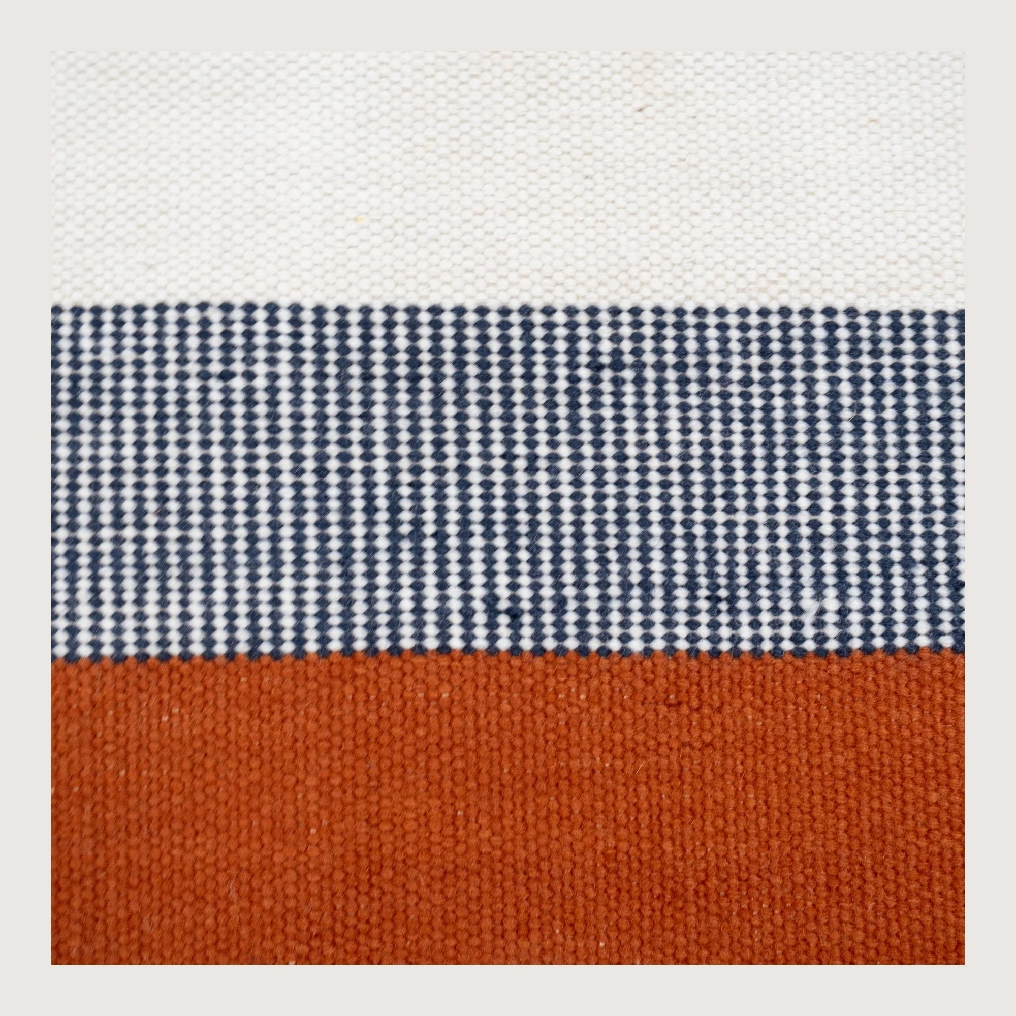 Handwoven wool flatweave runner with color block design in Bombay, deep neel, and whisper white tones.