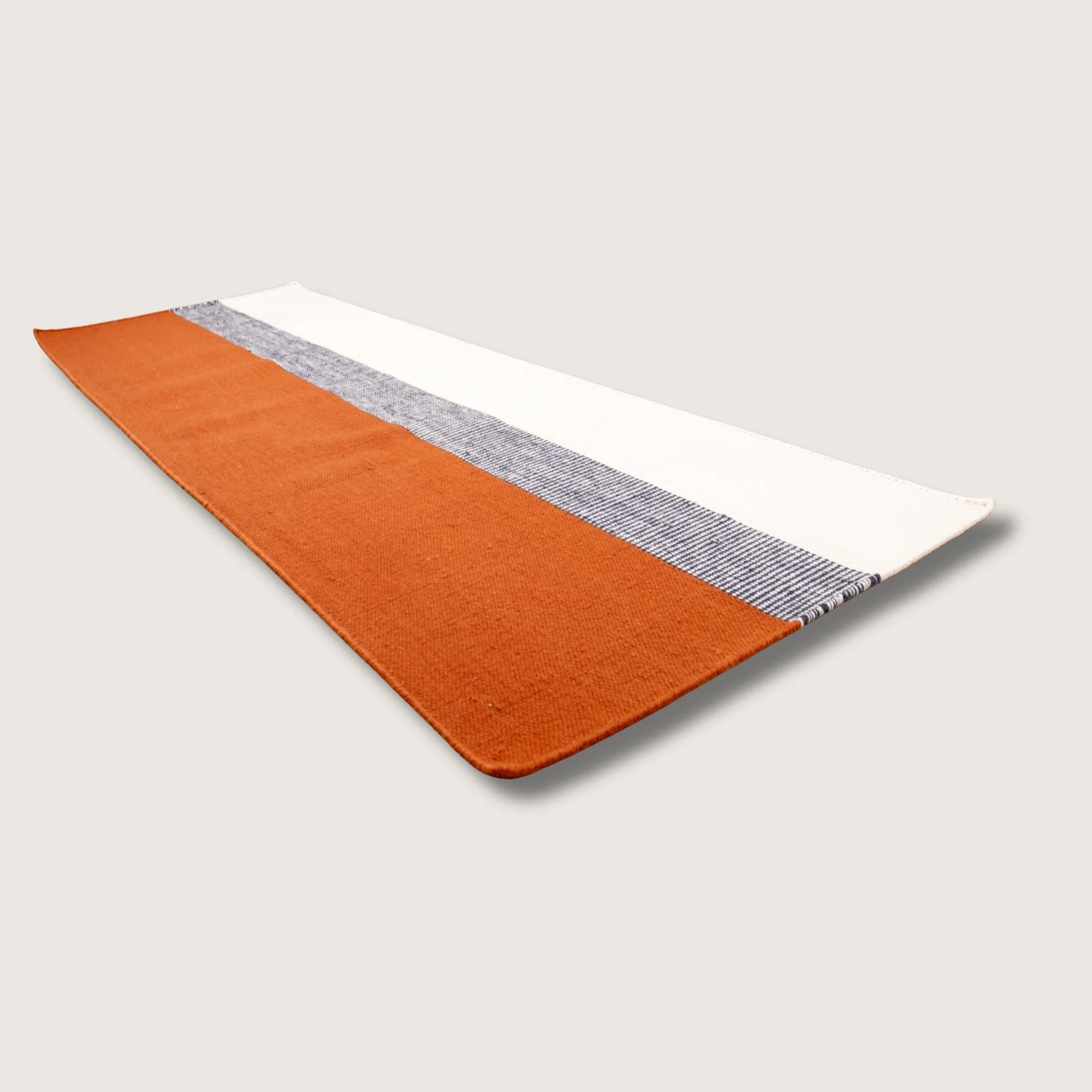 Handwoven wool flatweave runner with color block design in Bombay, deep neel, and whisper white tones.