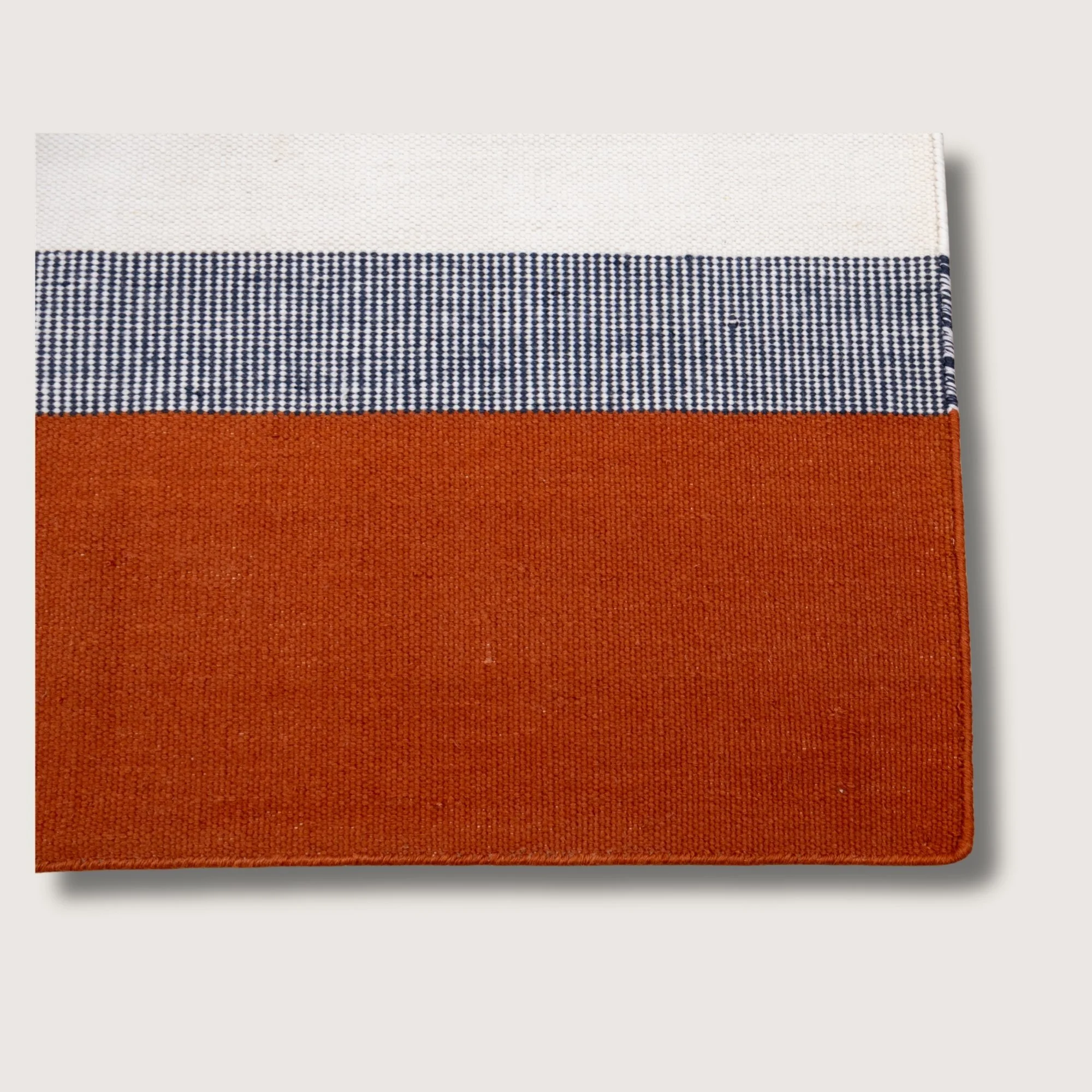 Handwoven wool flatweave runner with color block design in Bombay, deep neel, and whisper white tones.