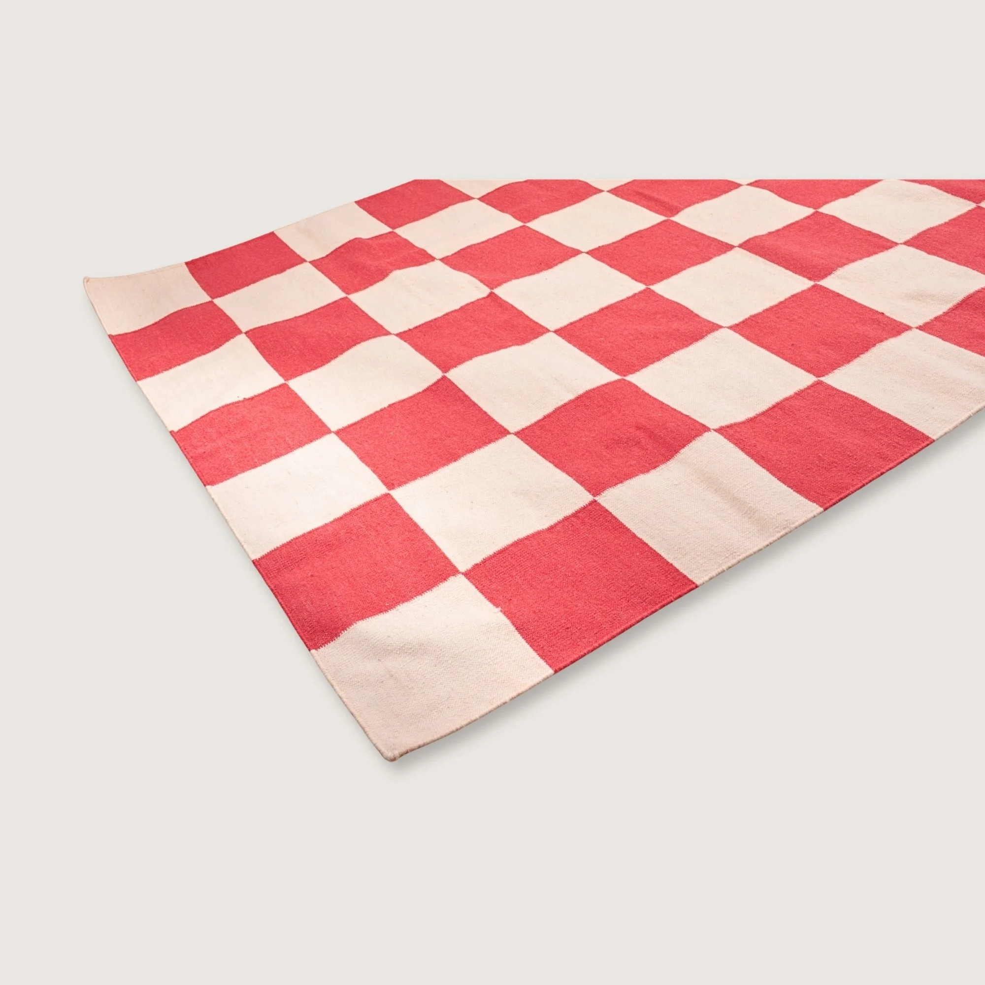 Handwoven wool flatweave rug with checkerboard pattern in red and natural tones