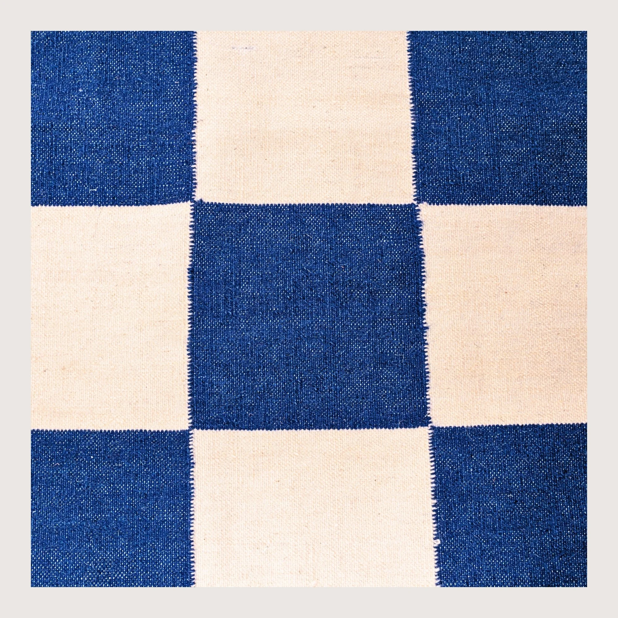 Khana Neel handwoven checkered wool rug with blue and natural squares, flatweave design