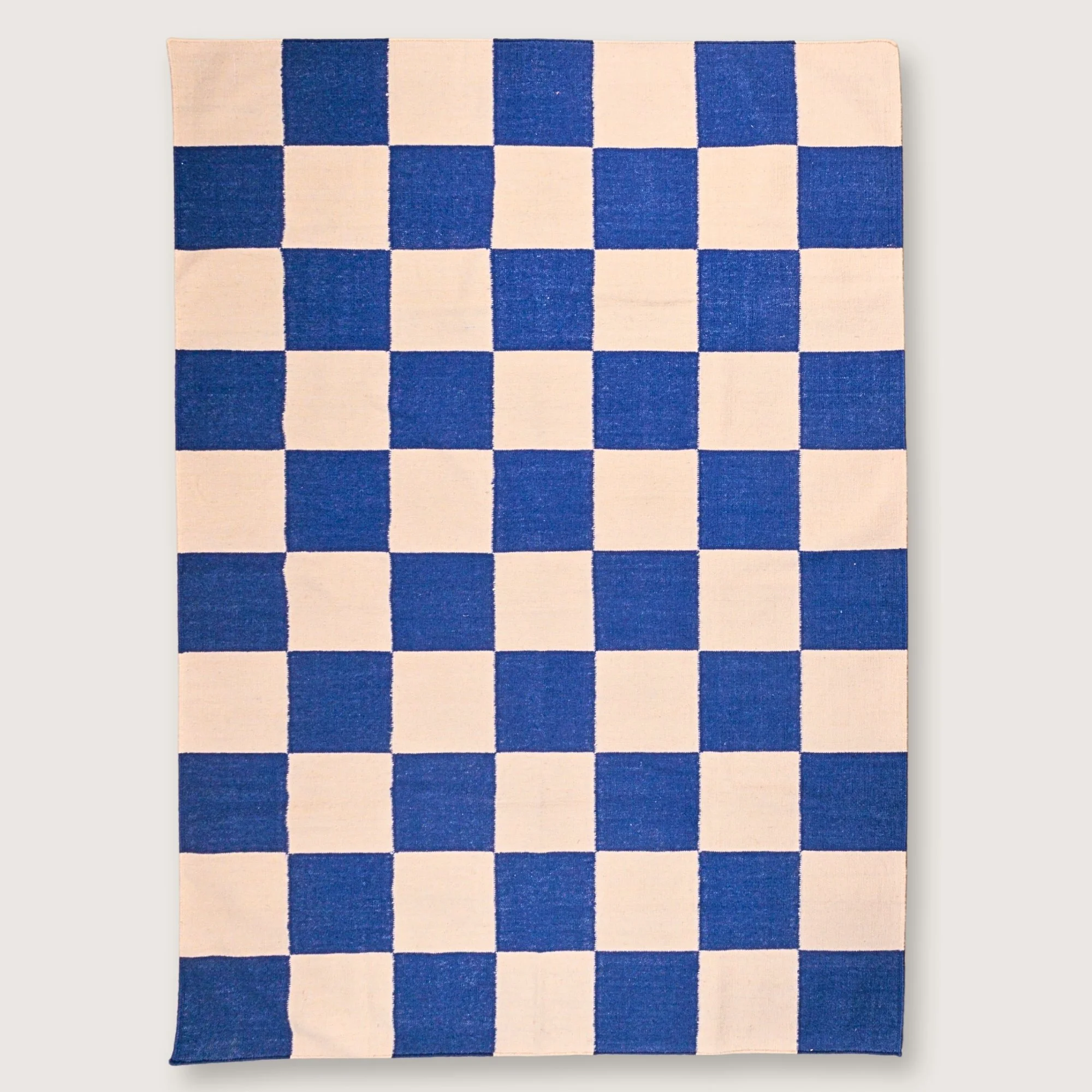 Khana Neel handwoven checkered wool rug with blue and natural squares, flatweave design