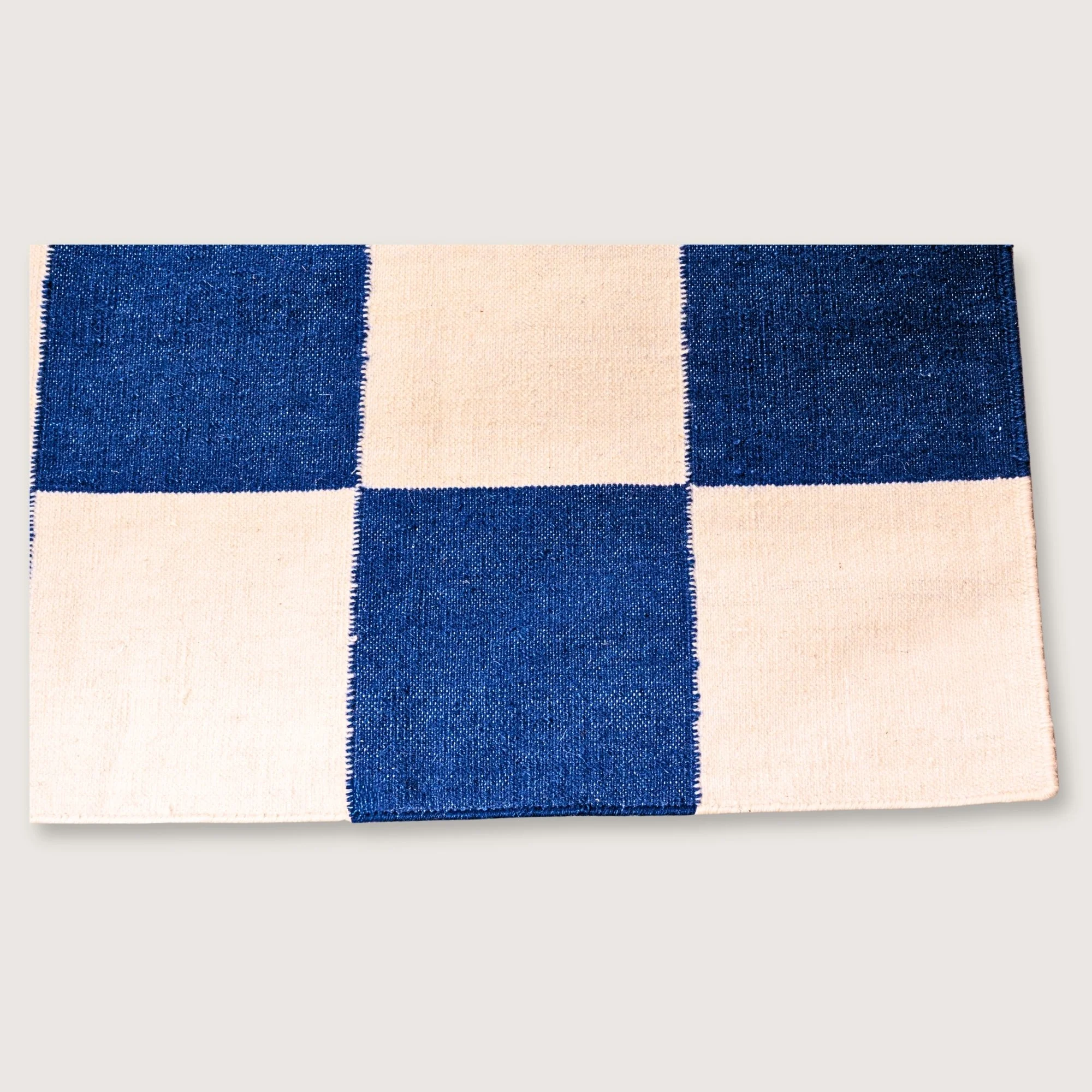 Khana Neel handwoven checkered wool rug with blue and natural squares, flatweave design