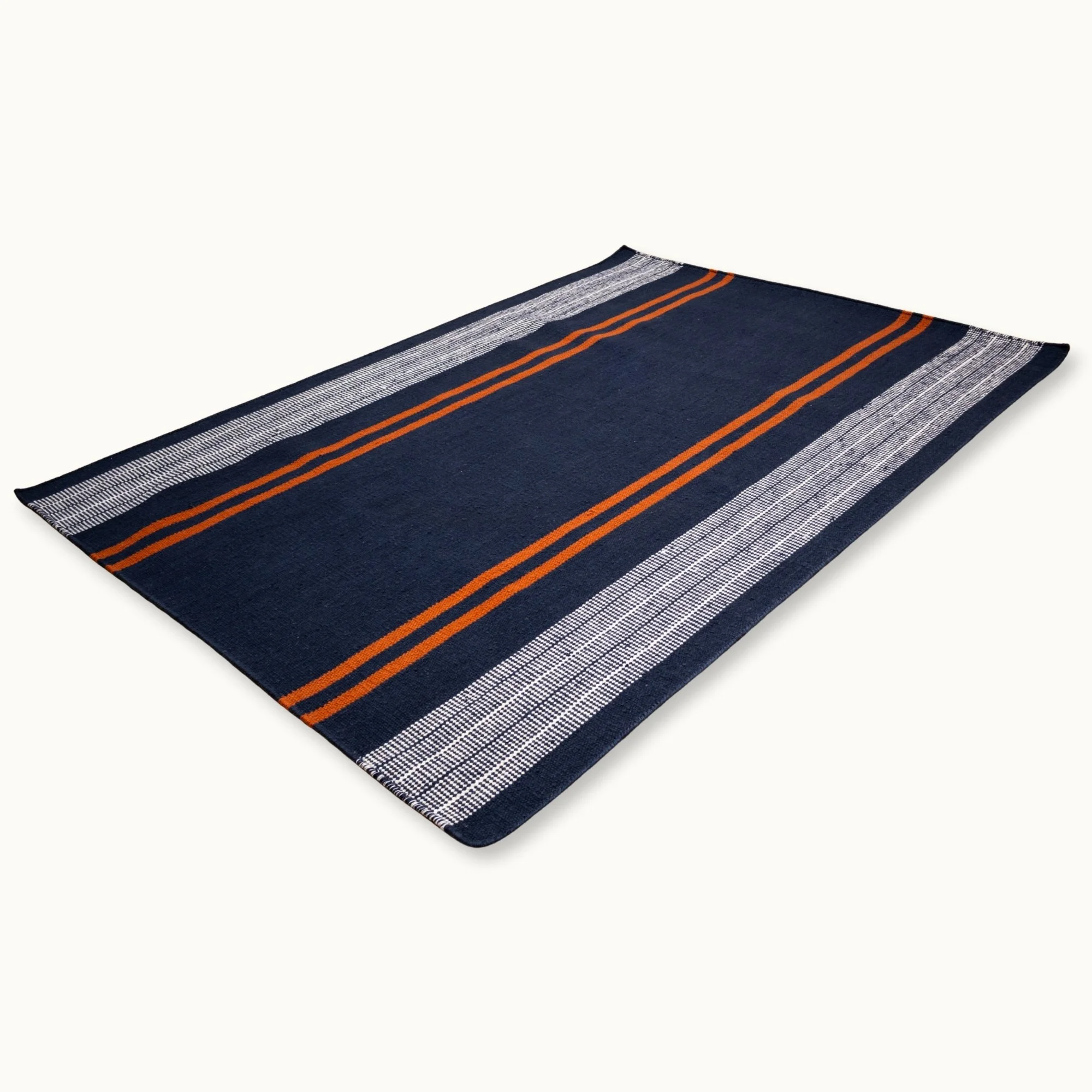 Handwoven wool flatweave rug with striped pattern in deep blue, whisper white, and Bombay brown tones.