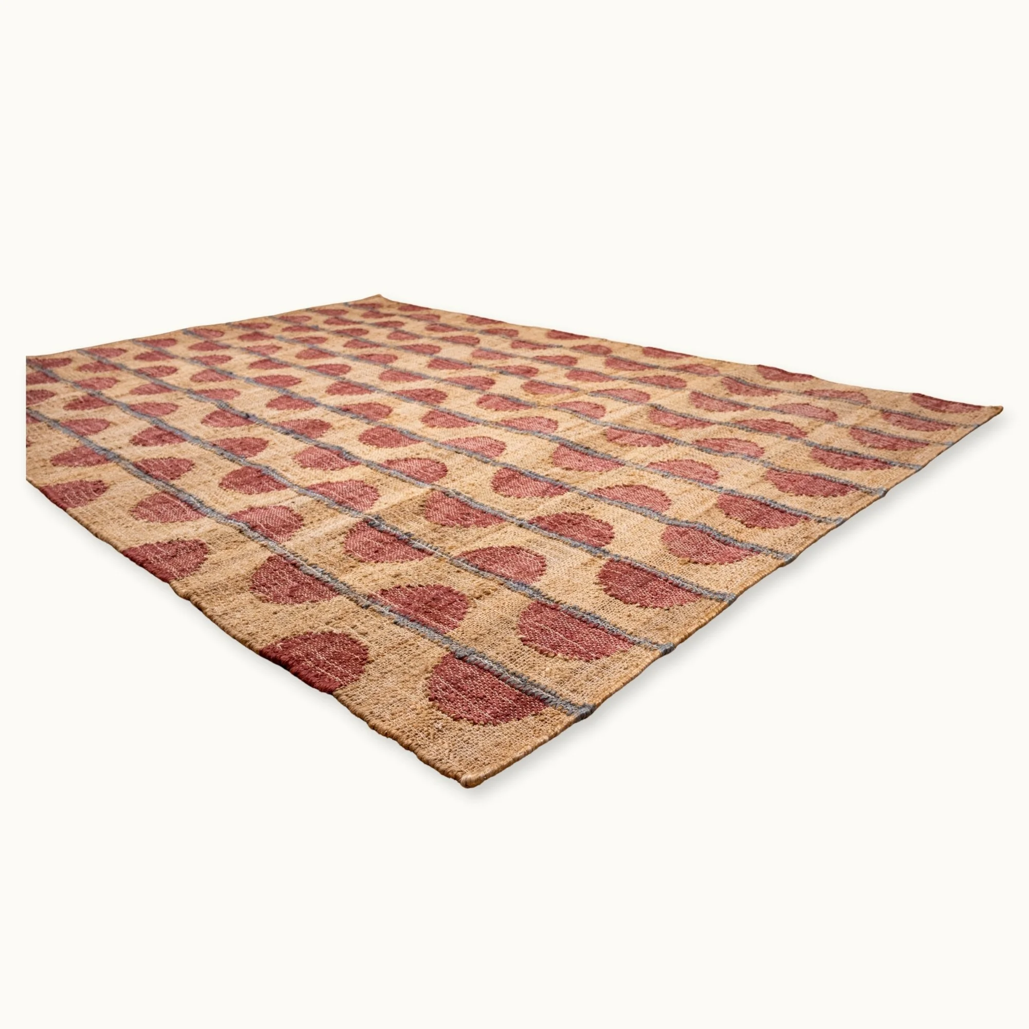Handwoven jute rug with repeating half-moon pattern in dusty rose and natural sand tones.