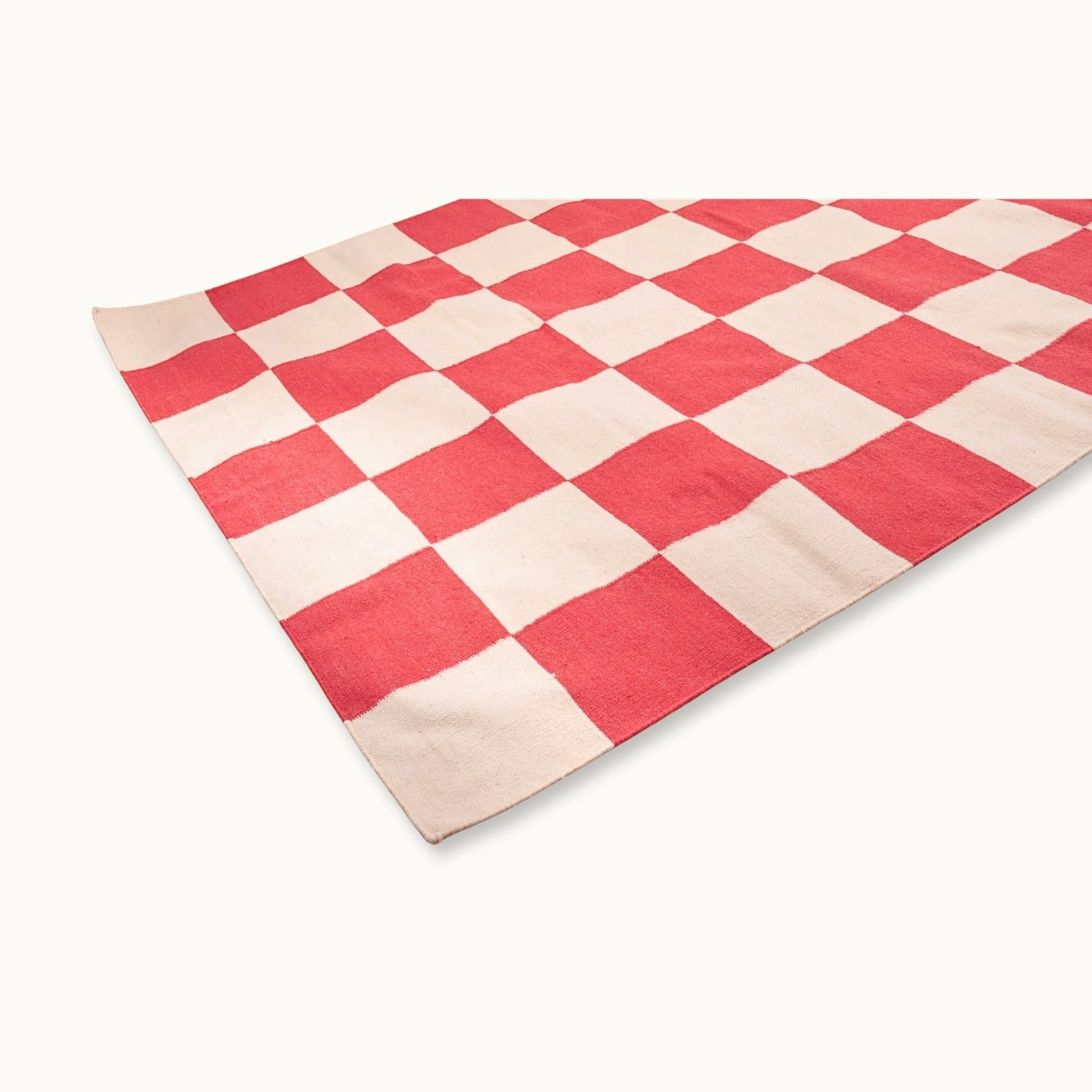 Handwoven wool flatweave rug with checkerboard pattern in red and natural tones