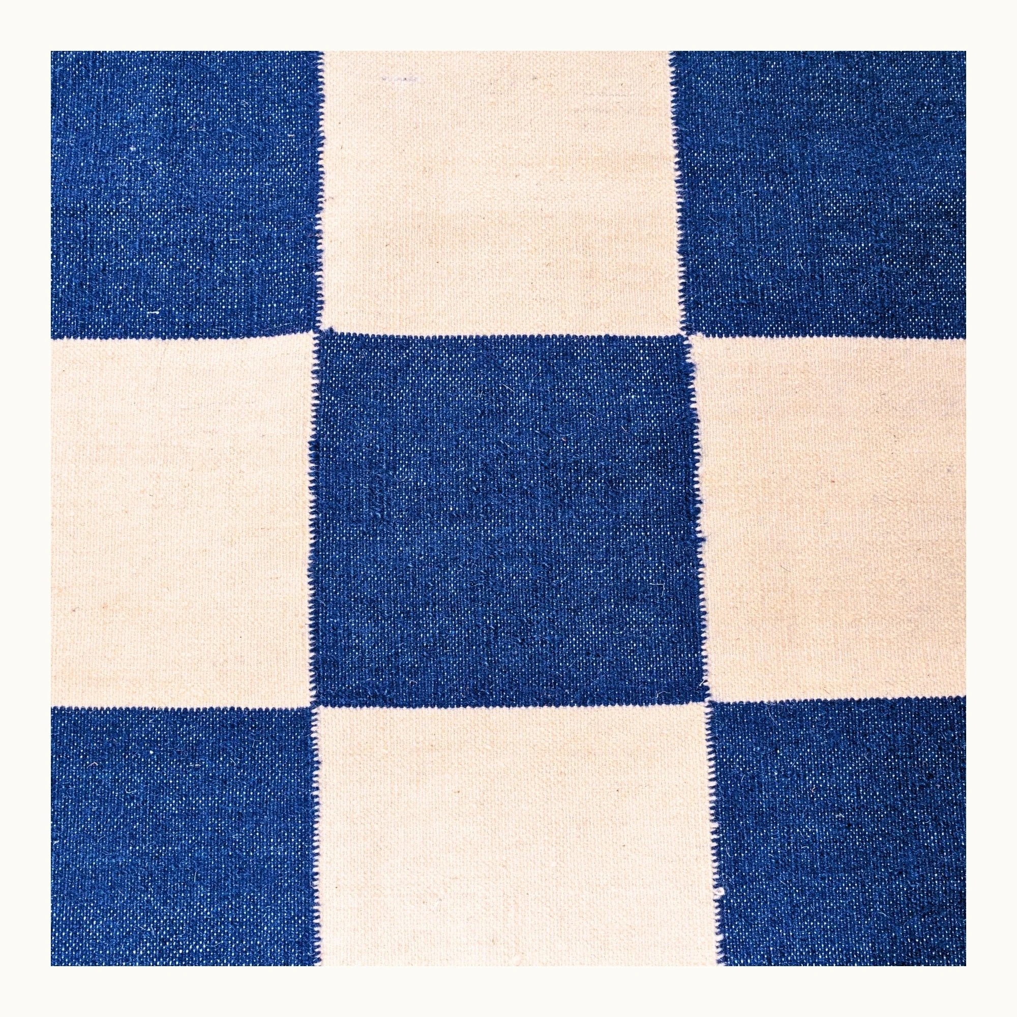 Khana Neel handwoven checkered wool rug with blue and natural squares, flatweave design
