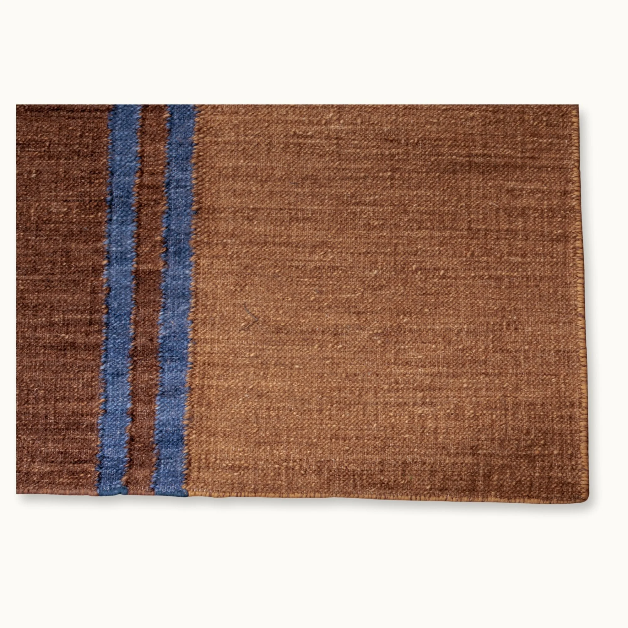 Rekha Do handwoven rug with double blue line detail and natural wool texture