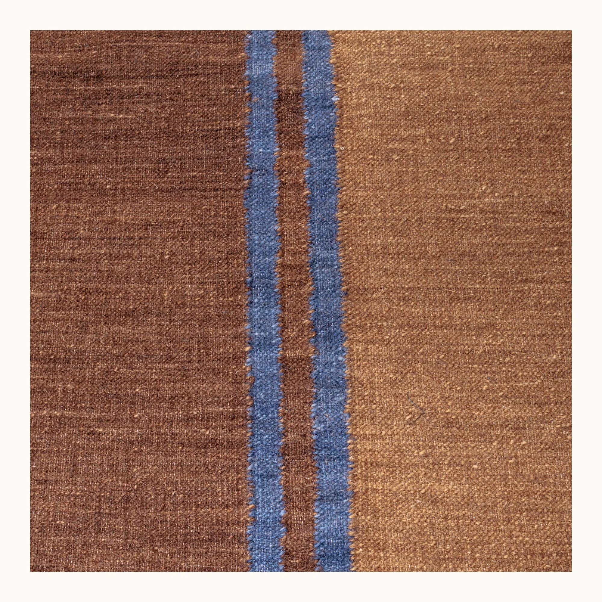 Rekha Do handwoven rug with double blue line detail and natural wool texture
