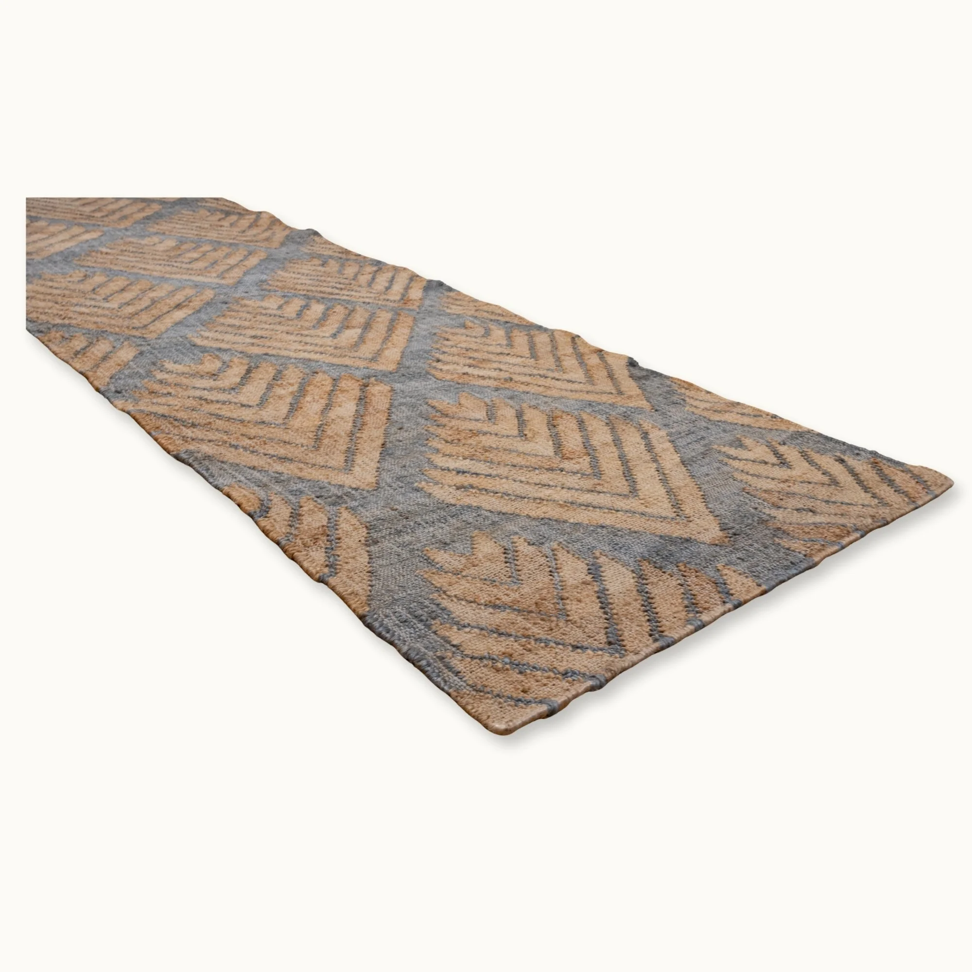 Handgeweven jute loper met een platgeweven structuur en een geometrisch patroon geïnspireerd op palmbladeren, uitgevoerd in gedempte blauwe en natuurlijke zandtinten.
