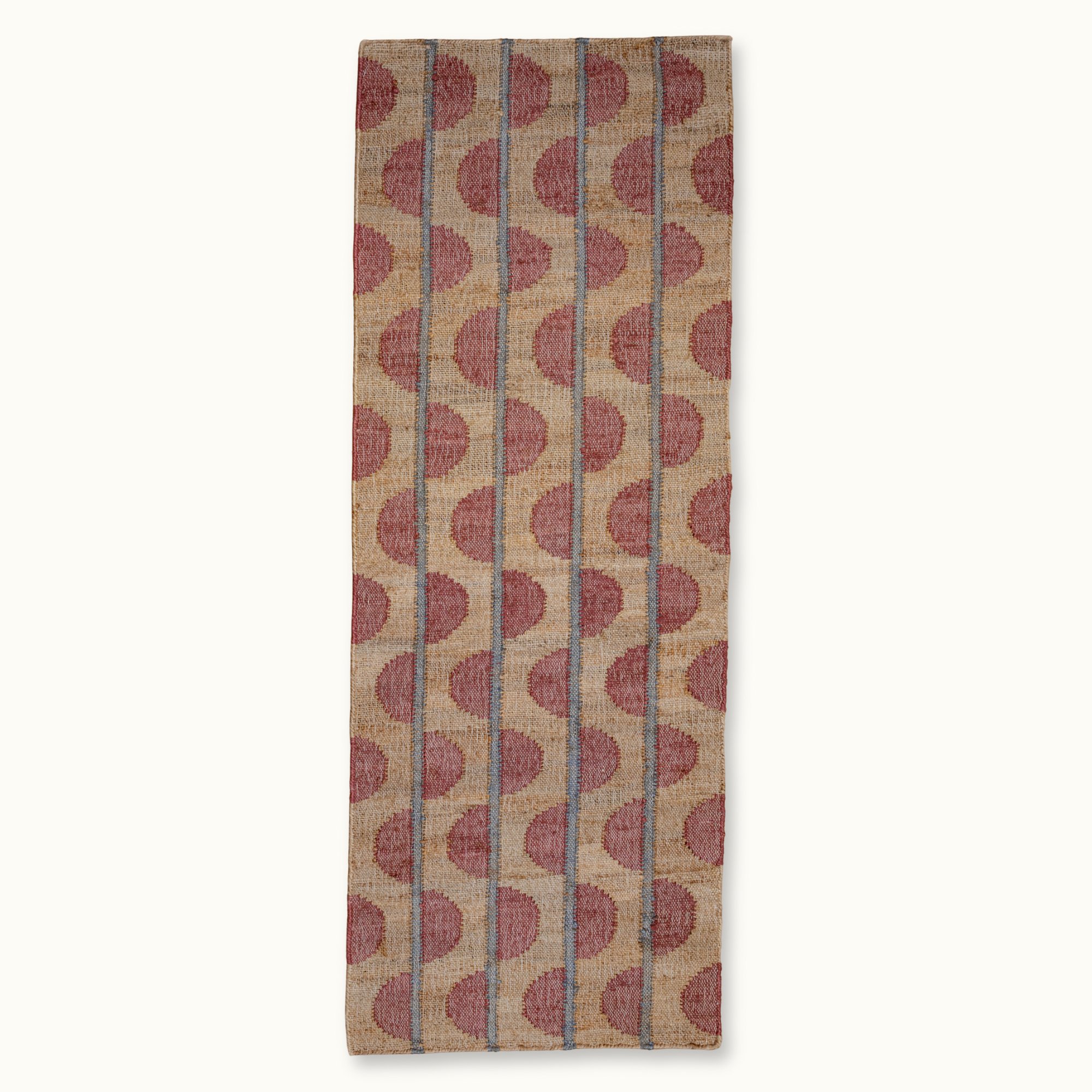 Handwoven jute rug with repeating half-moon pattern in dusty pink and natural sand tones.