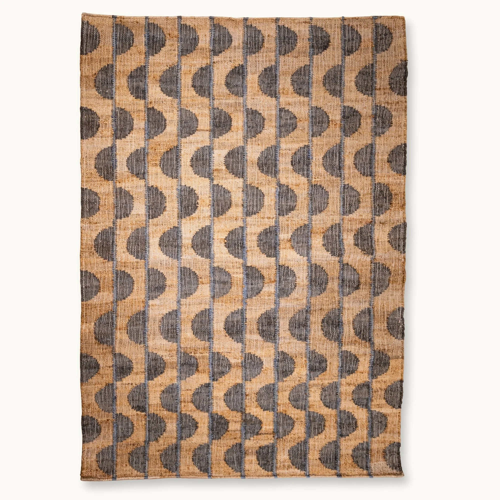 Handwoven jute rug with repeating half-moon pattern in muted olive green and natural sand tones.