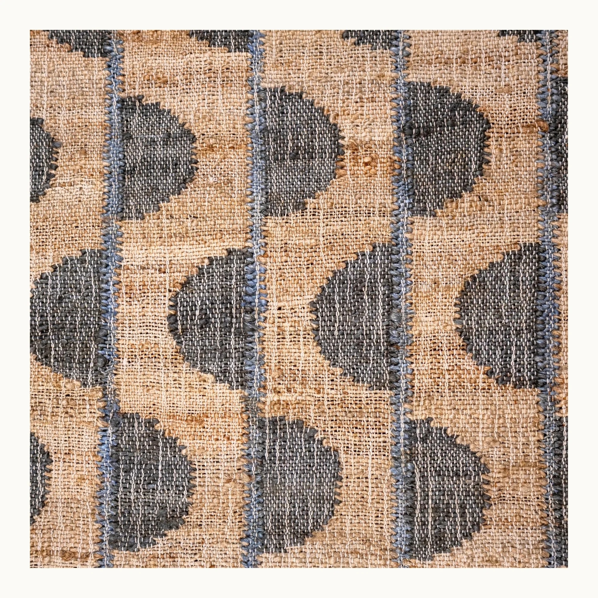 Handwoven jute rug with repeating half-moon pattern in muted olive green and natural sand tones.