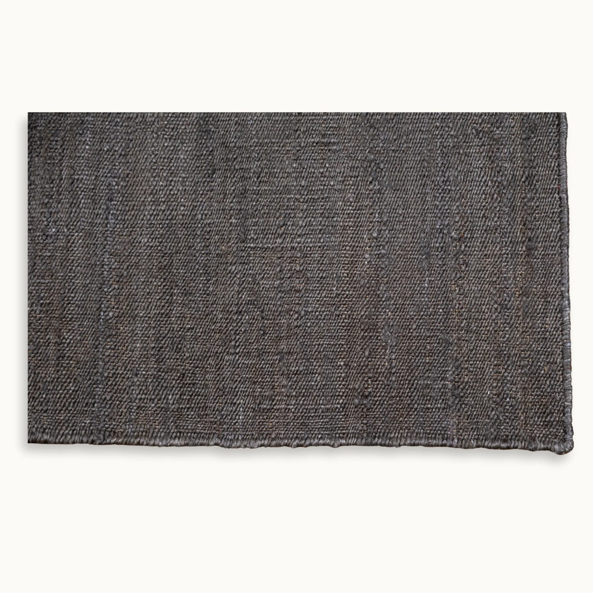 Een eenvoudig, handgeweven jute vloerkleed in ingetogen olijfgroene tinten met een subtiele natuurlijke structuur.