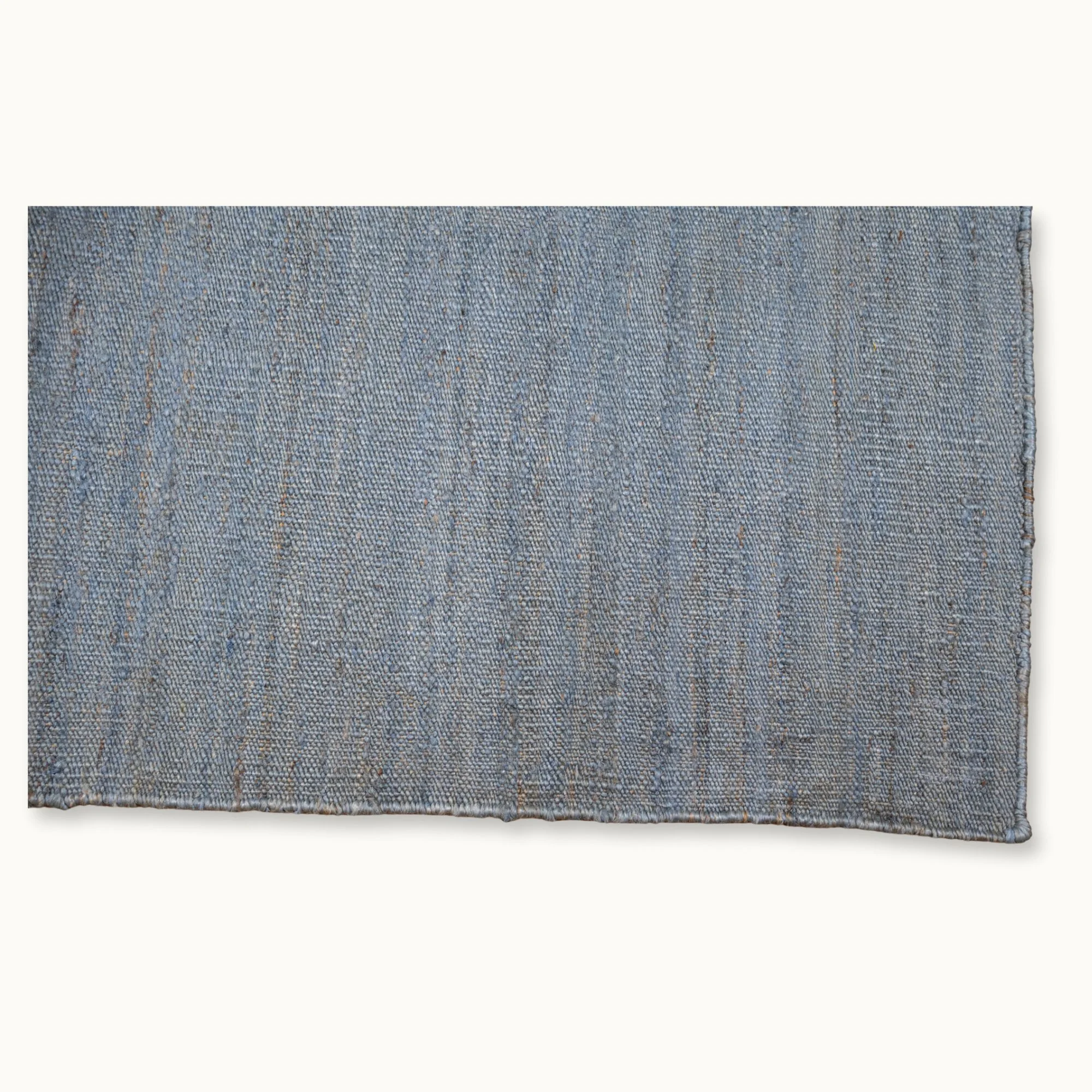 Een eenvoudig, handgeweven jute vloerkleed in ingetogen blauwtinten met een subtiele natuurlijke structuur.