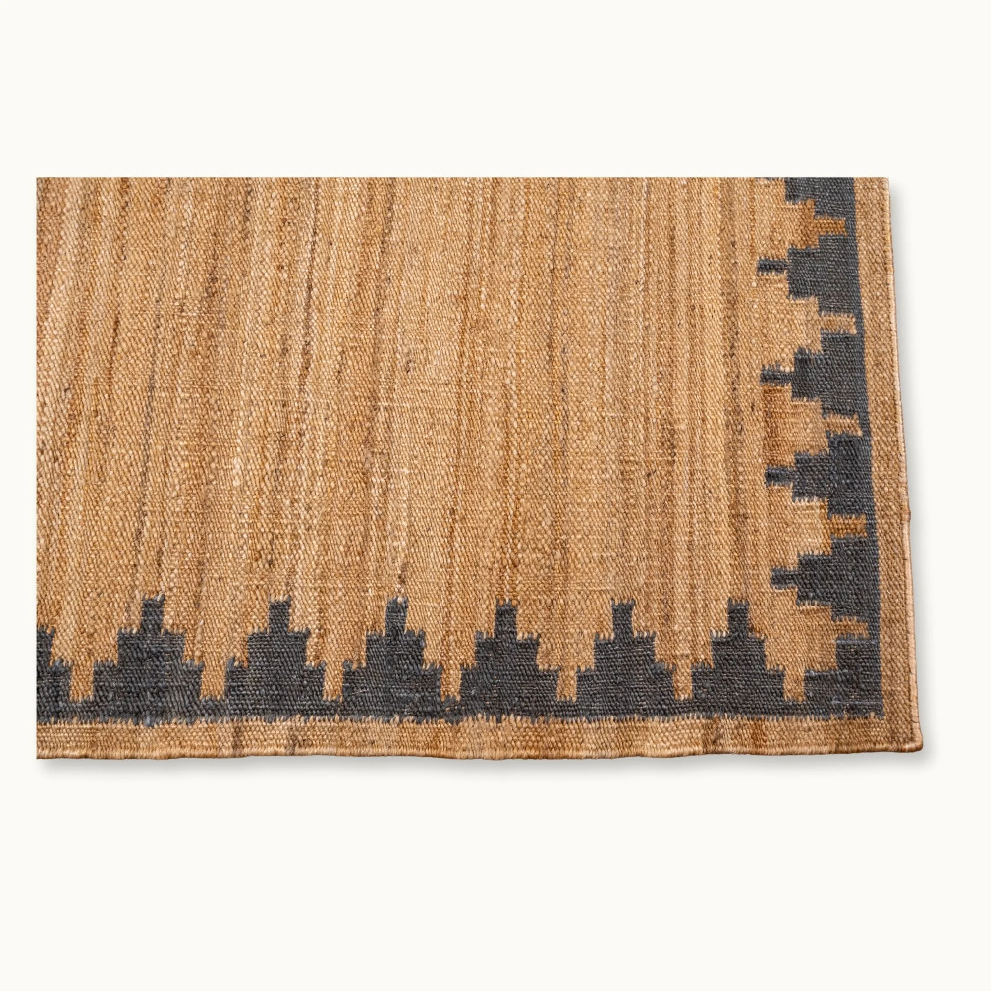 Handgeweven jute vloerkleed met een trapsgewijze geometrische rand in ingetogen olijfgroene en natuurlijke zandtinten.