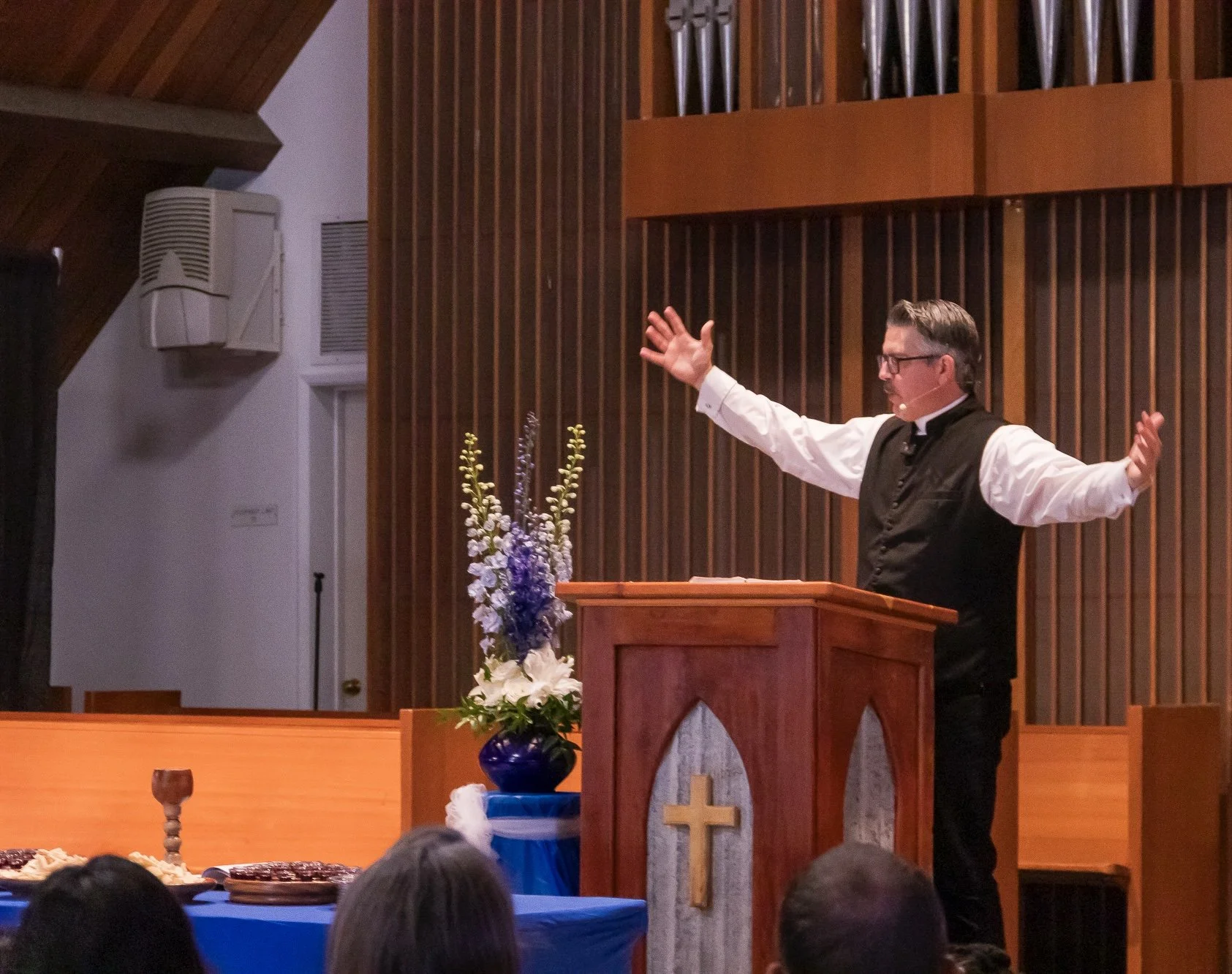 Dr. Daniel R. Hyde of Oceanside United Reformed Church preaching in a white clerical shirt with black vet over it