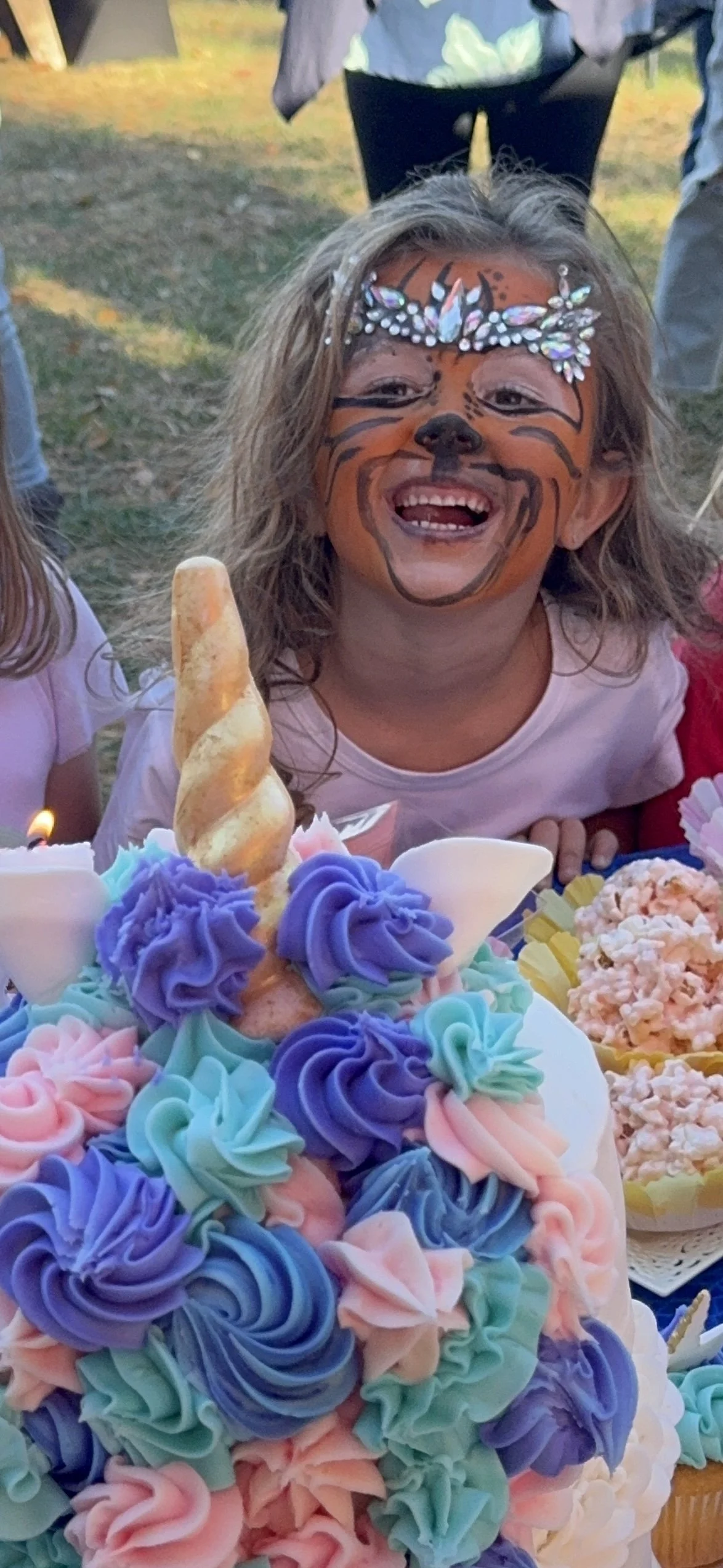 Little girl with face painting and unicorn birthday cake celebrating in Monmouth County NJ - party rentals and celebrations by CelebrationShare