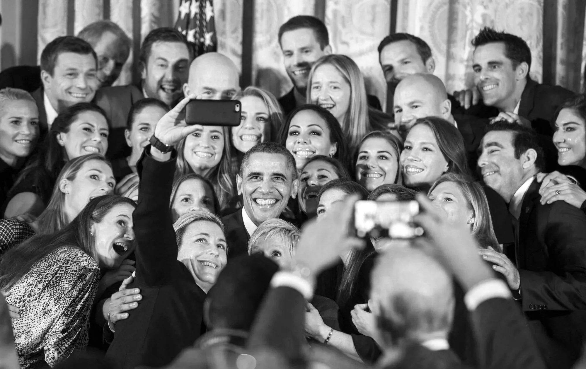 Group of people taking a selfie together, smiling and posing for the camera.