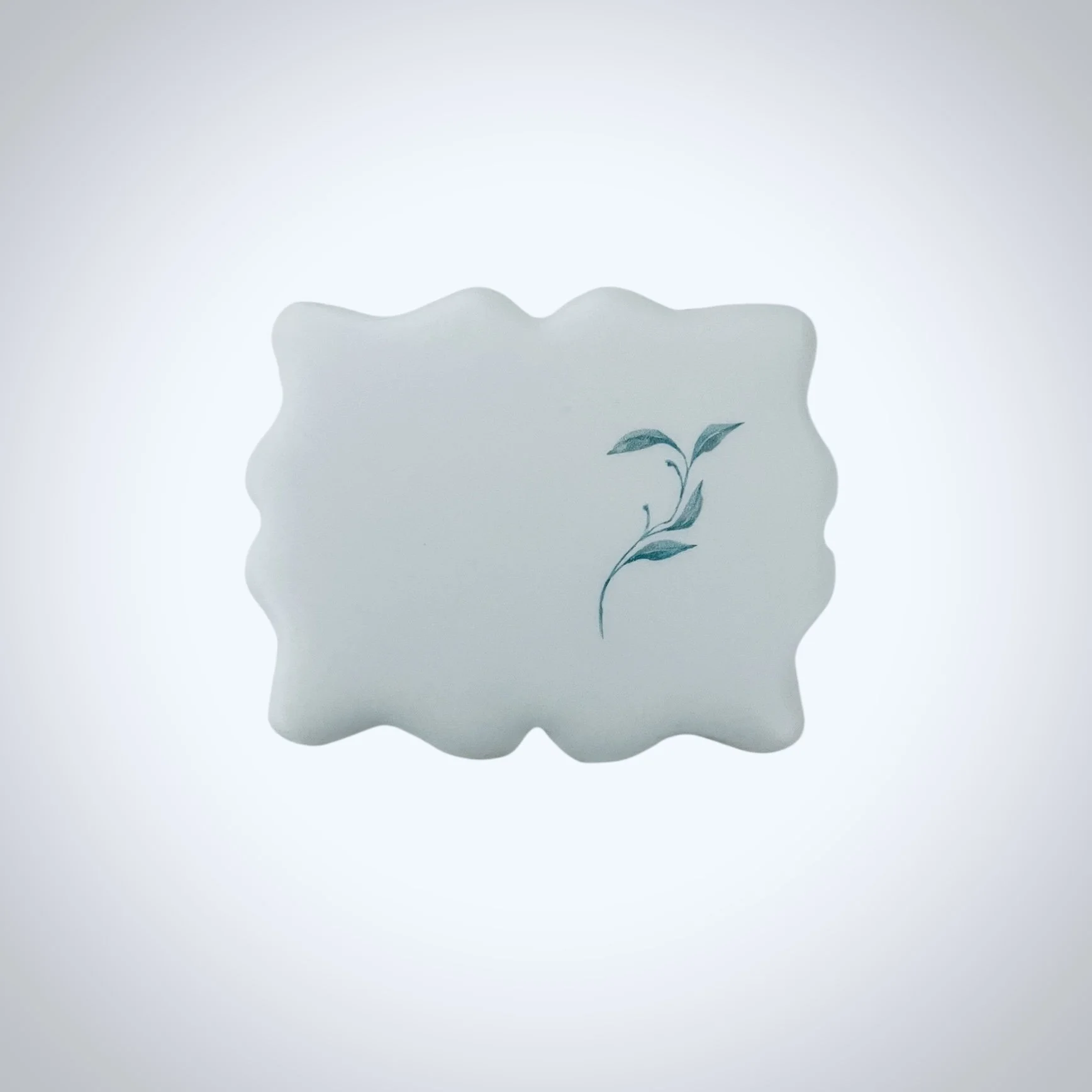 Scalloped shaped cookie with white icing and a minimal botanical design printed with edible ink. Designed for corporate gifting, branded events and client appreciation gifts. photographed on a white background.