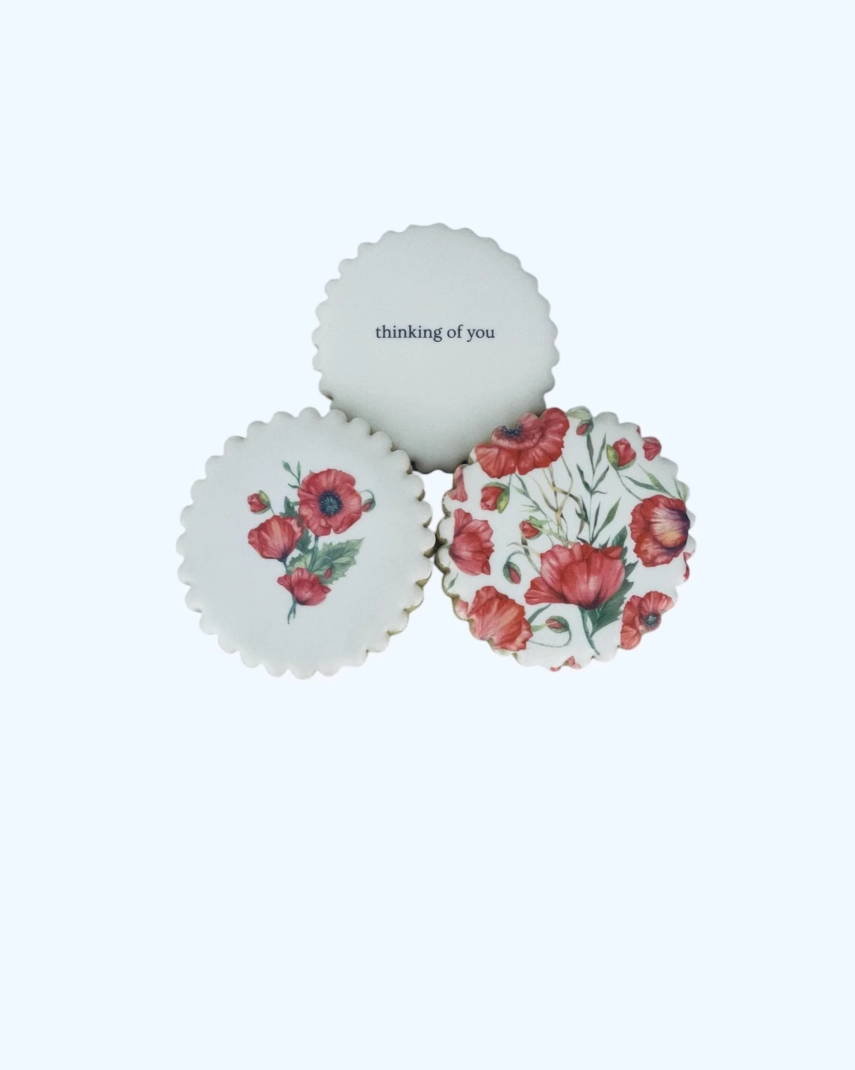 close up of floral sugar cookies with red flower bouquet design and a message cookie