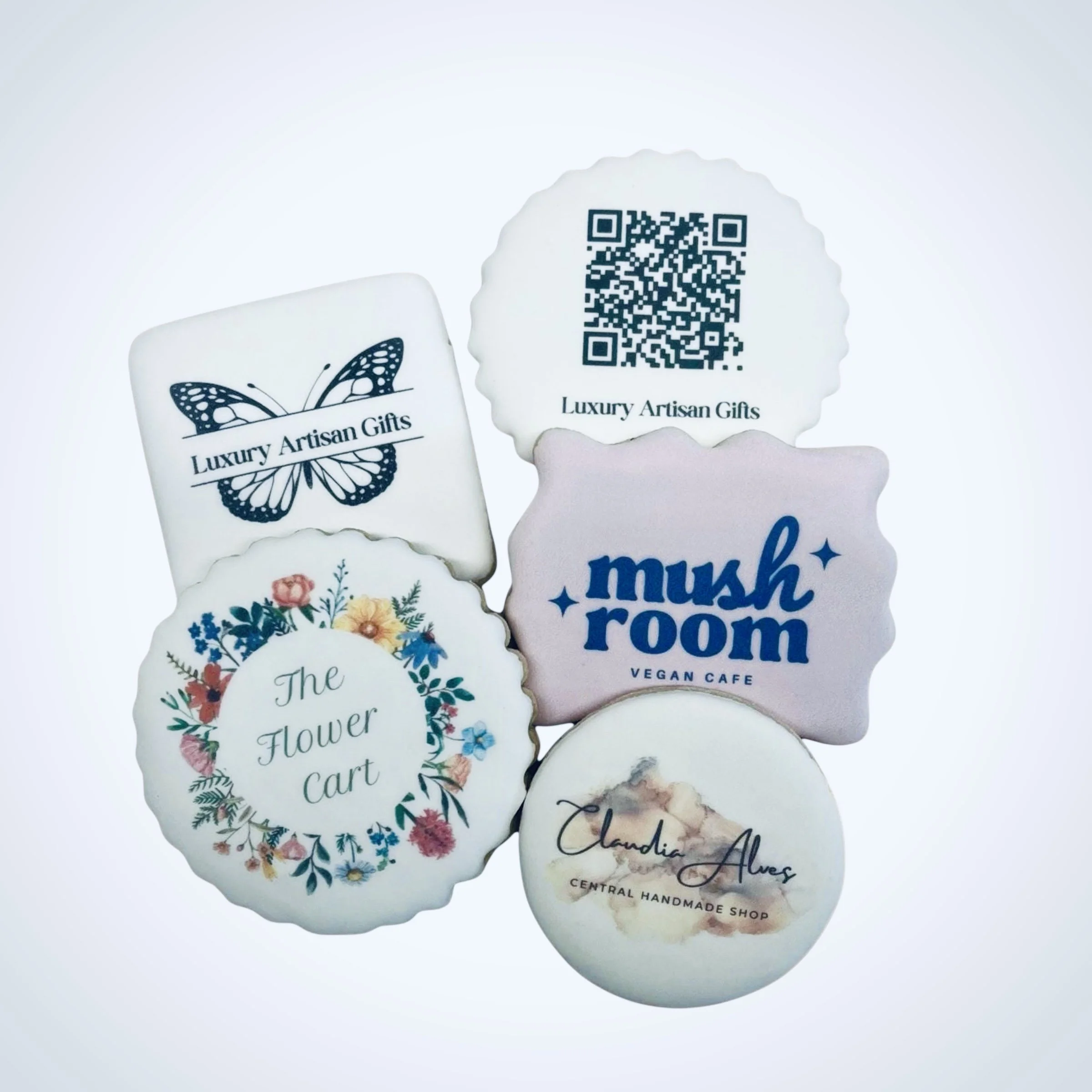 Custom logo cookies set with multiple brand designs in assorted shapes, printed on white icing