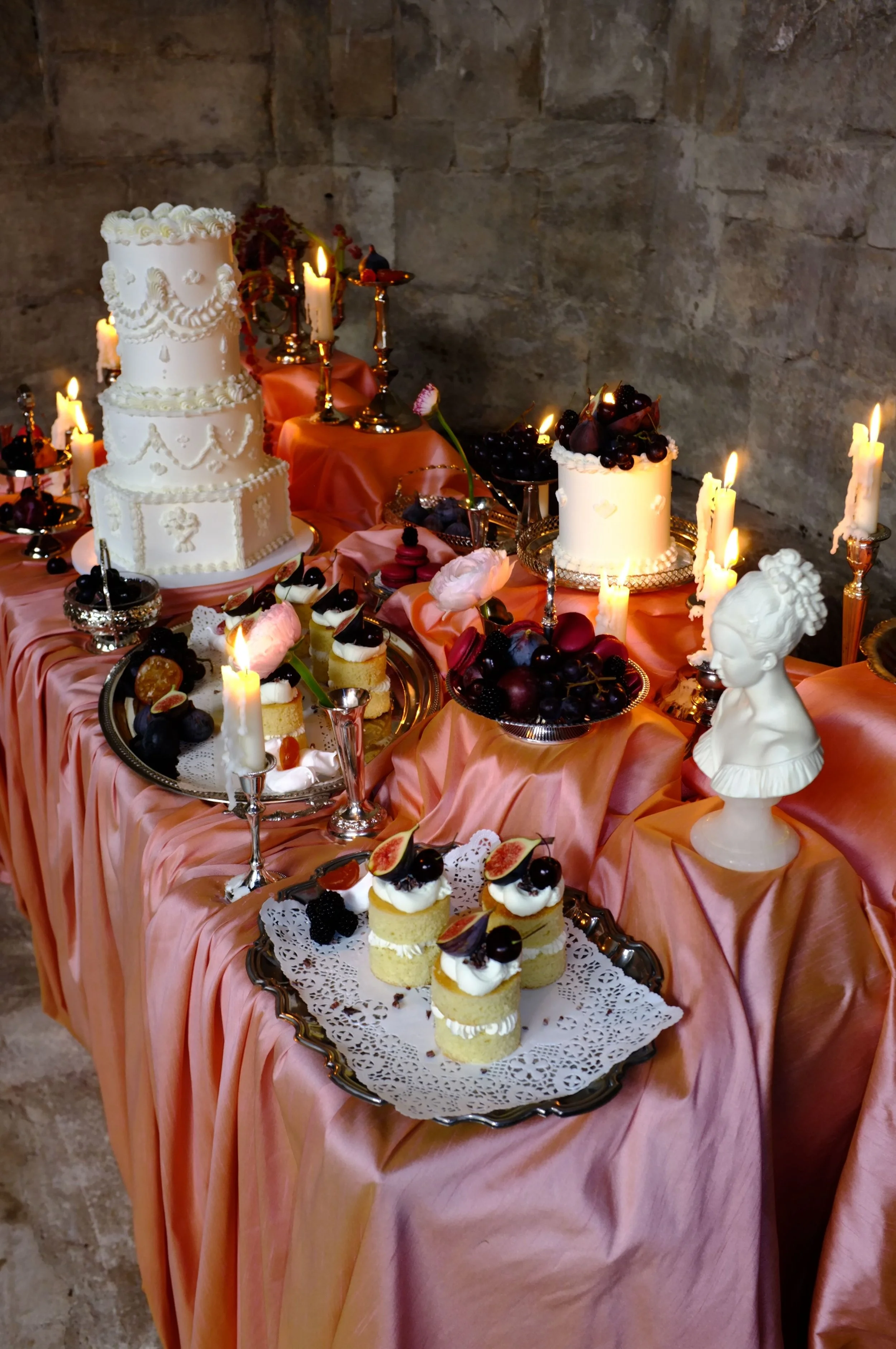 Luxury pink wedding dessert table styled with vintage silverware, antique cake stands and romantic Victorian-inspired details