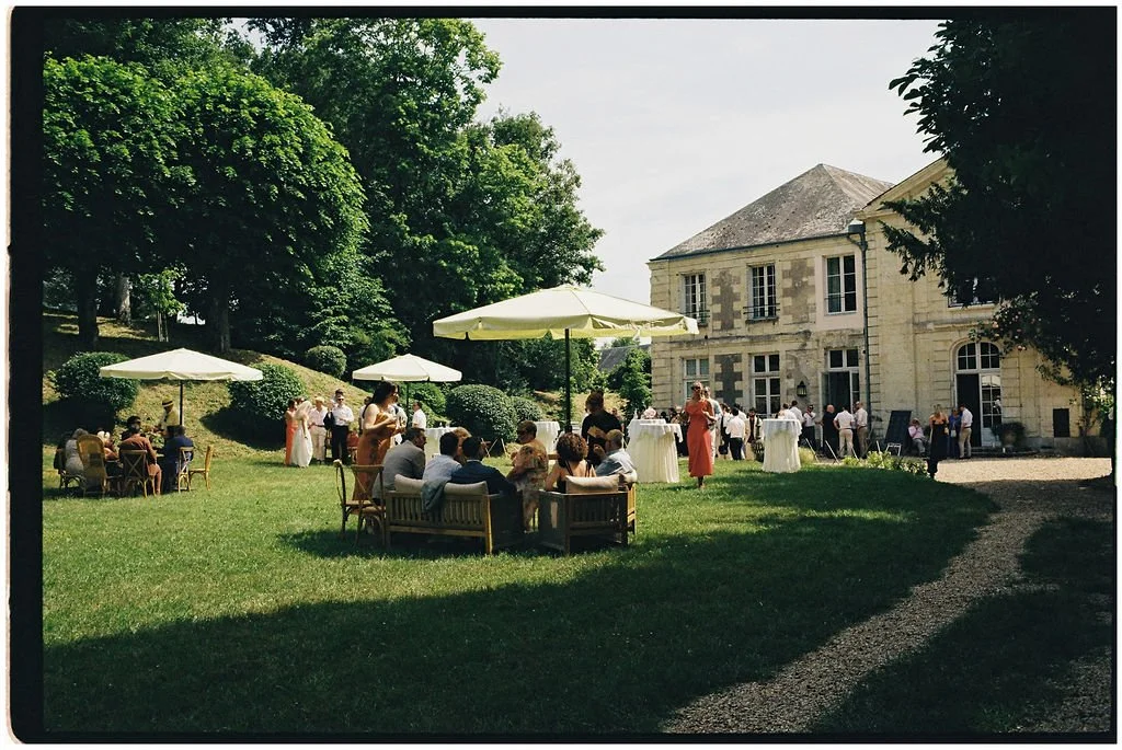 Guests enjoying a relaxed château garden drinks reception with live jazz, rosé stations and lawn games at a Loire Valley destination wedding.