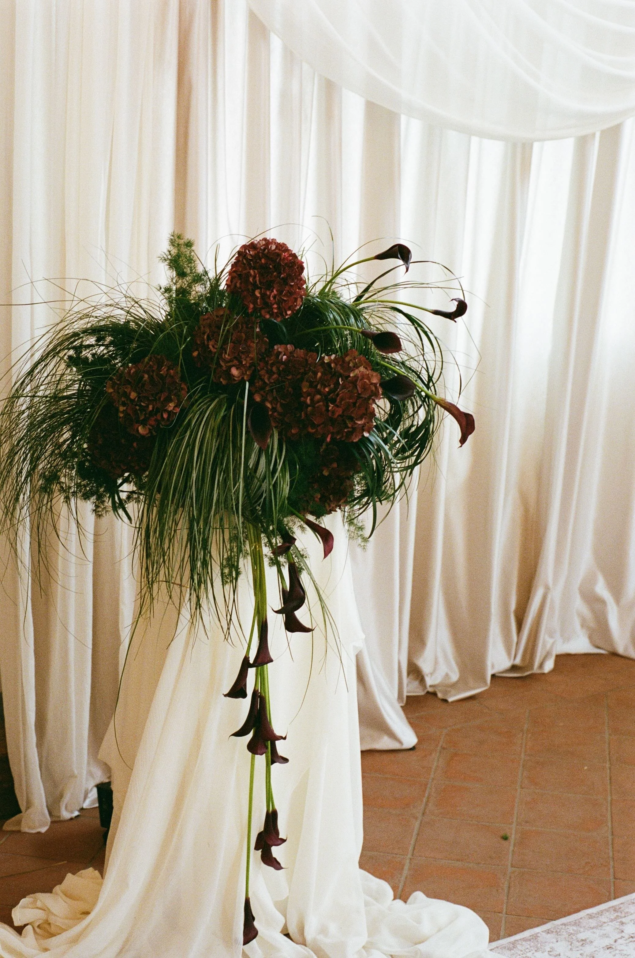 Evening destination wedding celebration at Fattorie di Celli in Tuscany with dramatic lighting, florals and bespoke event styling.