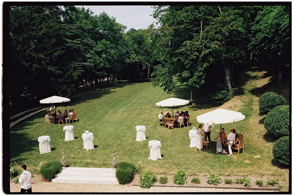 Guests enjoying a relaxed château garden drinks reception with live jazz, rosé stations and lawn games at a Loire Valley destination wedding.