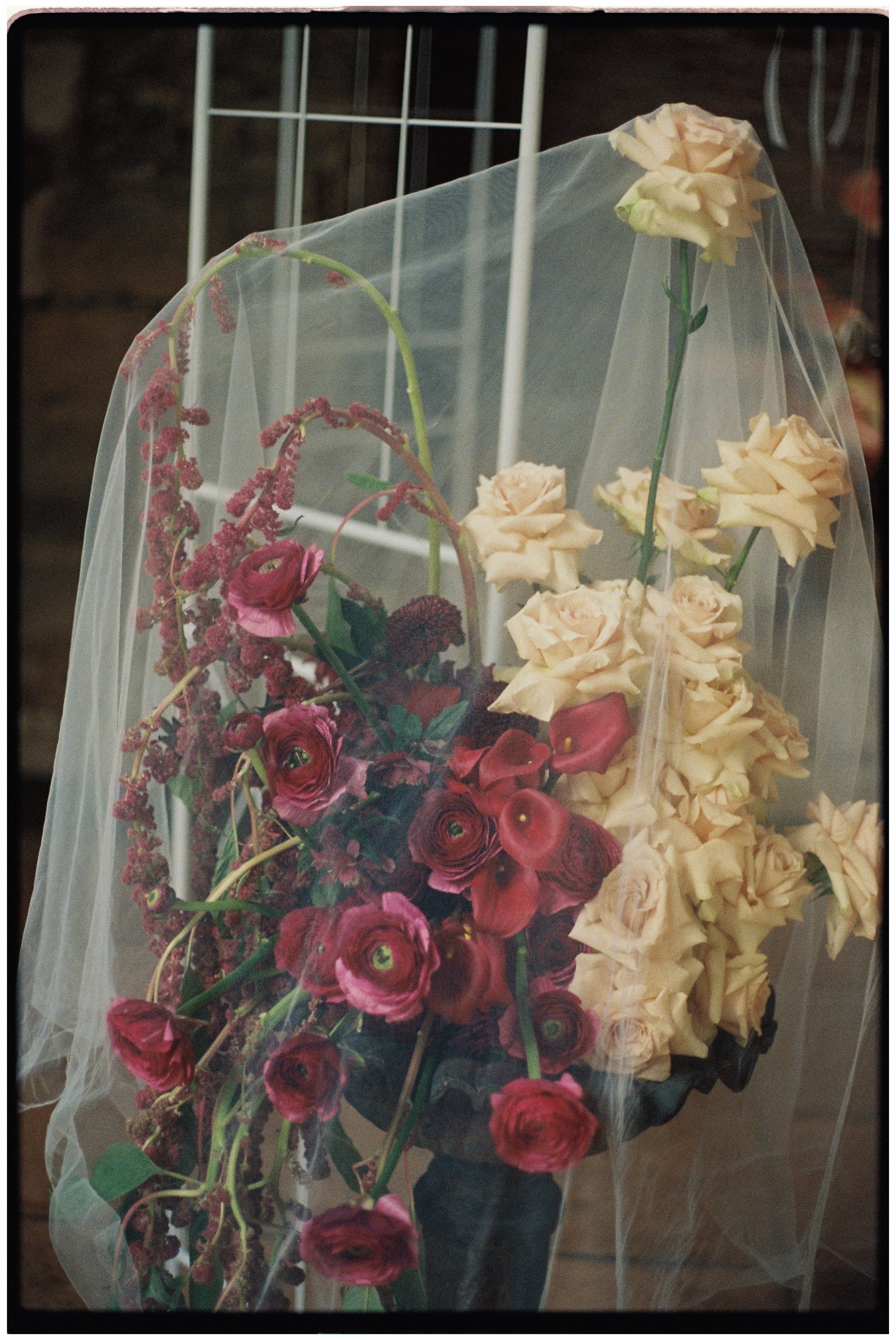 Fine art wedding tablescape with loose garden-style flowers, antique silver and soft candlelight
