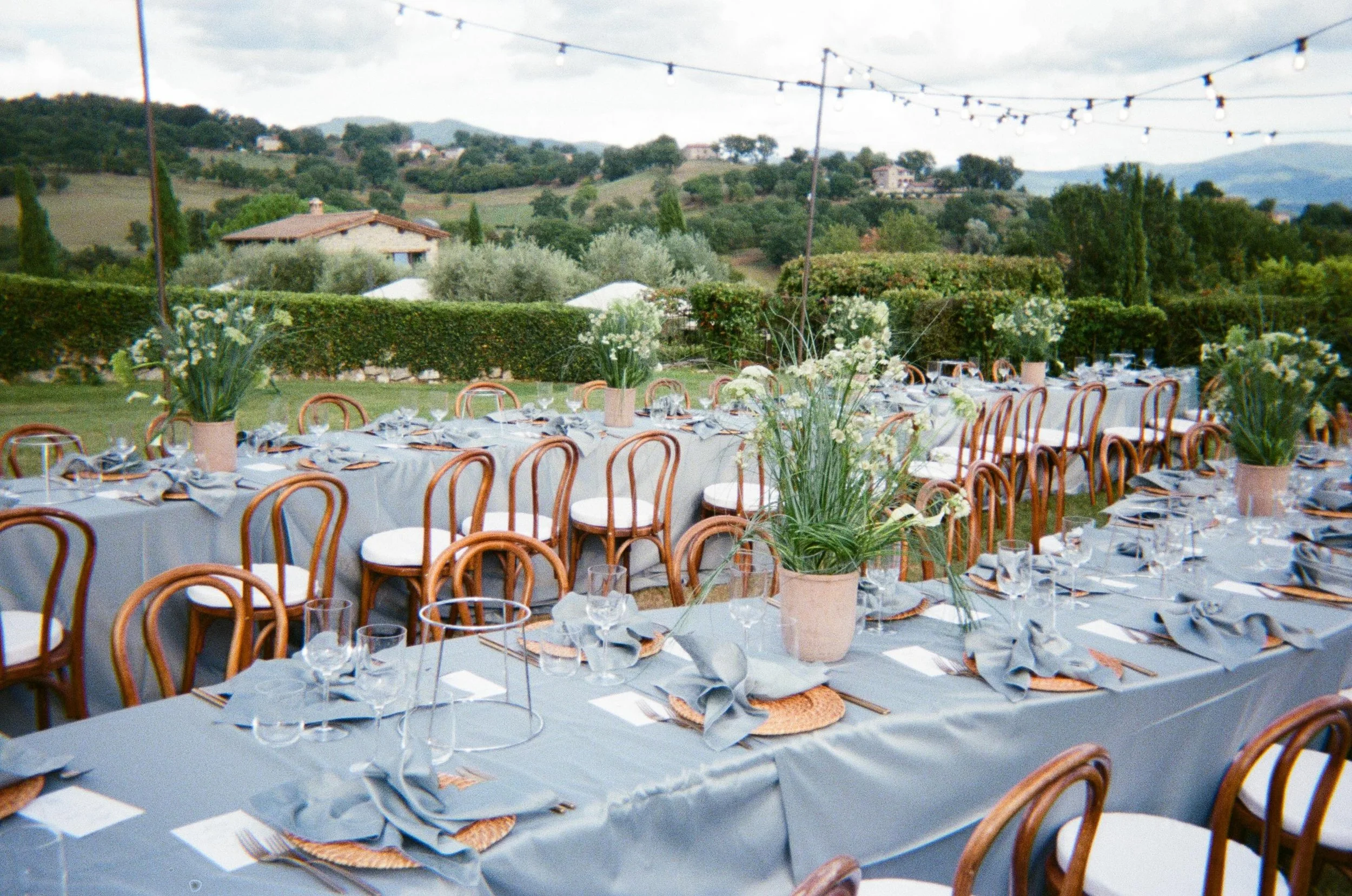 Tuscany wedding weekend featuring an intimate garden celebration surrounded by greenery, flowers and historic Italian architecture.