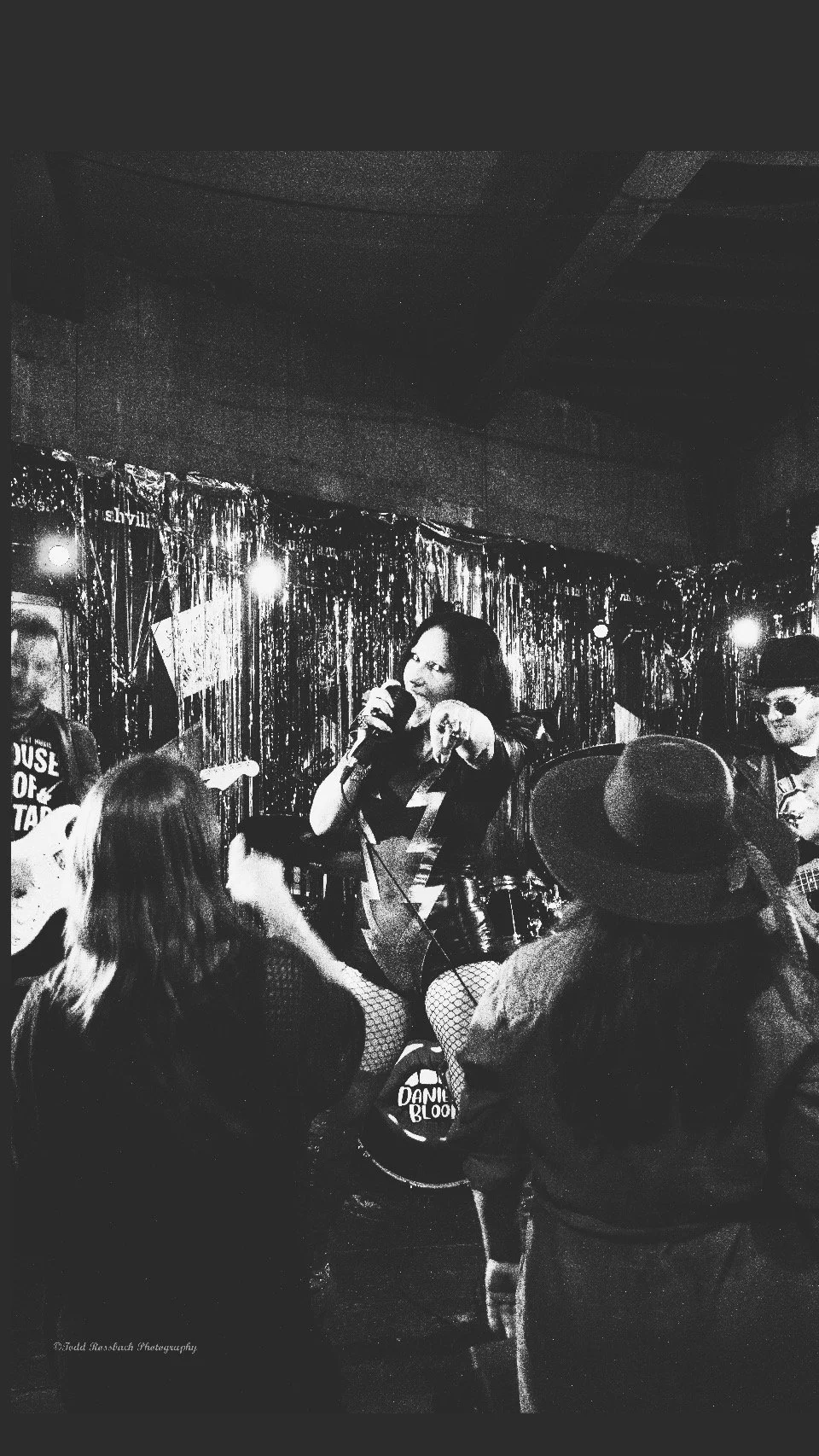 Danielle Bloom performing live with her band, connecting with audience members from the stage as part of the Wicked Warriors movement.