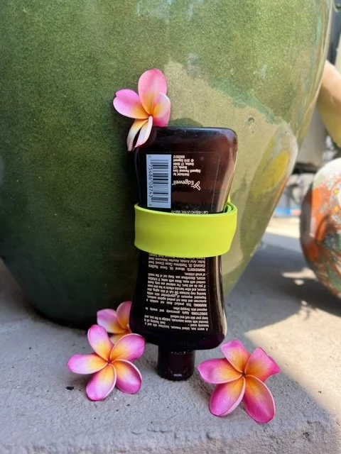 Colorful silicone bottle stabilizers with suction cups and water droplets, placed on a soapy surface. Bath and shower product organization. Garage organization.  Zero waste, save money. Every last drop. Lick it, Stick it and Flip it.