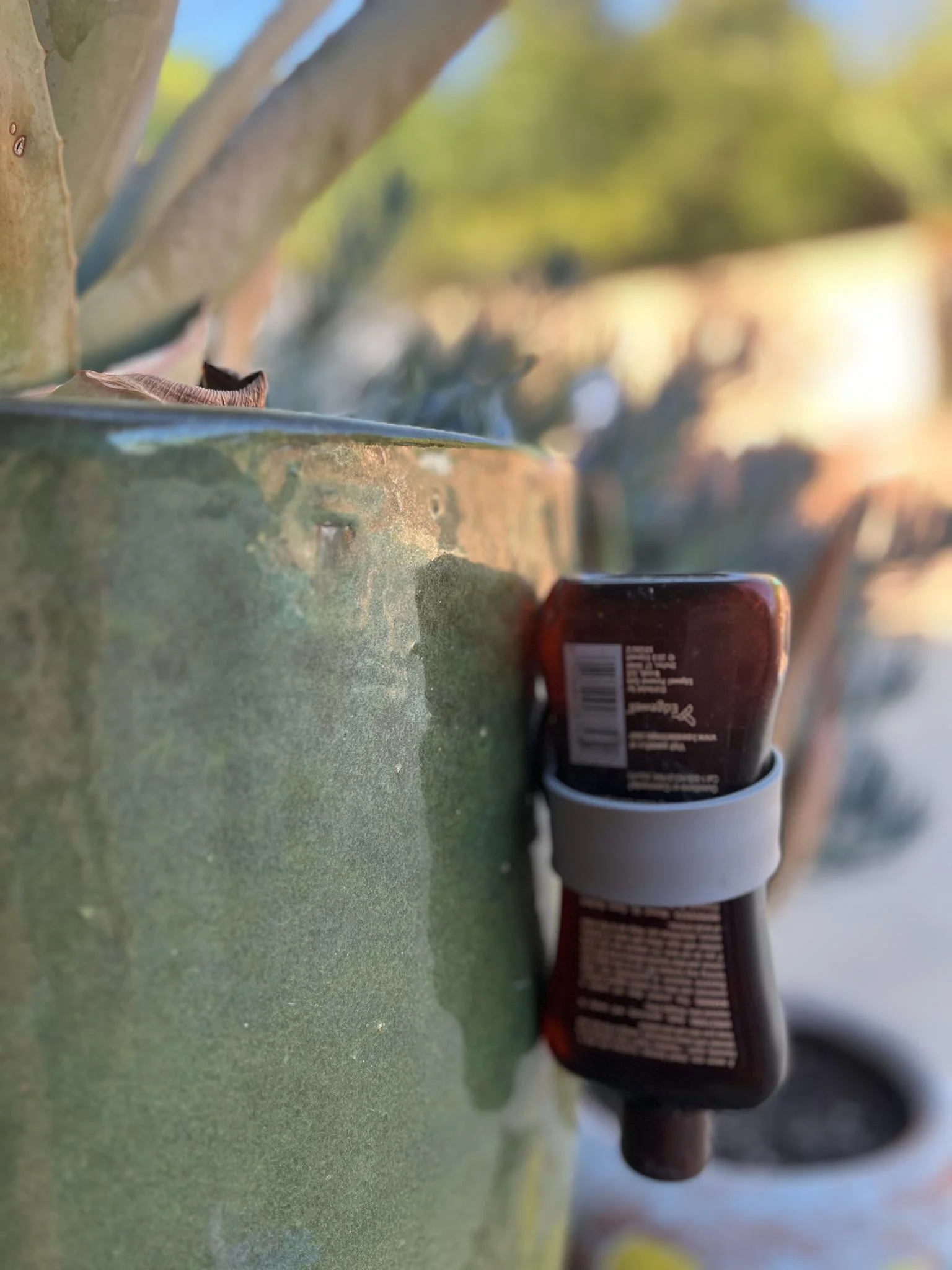 Colorful silicone bottle stabilizers with suction cups and water droplets, placed on a soapy surface. Bath and shower product organization. Zero waste, save money. Every last drop. Lick it, Stick it and Flip it.