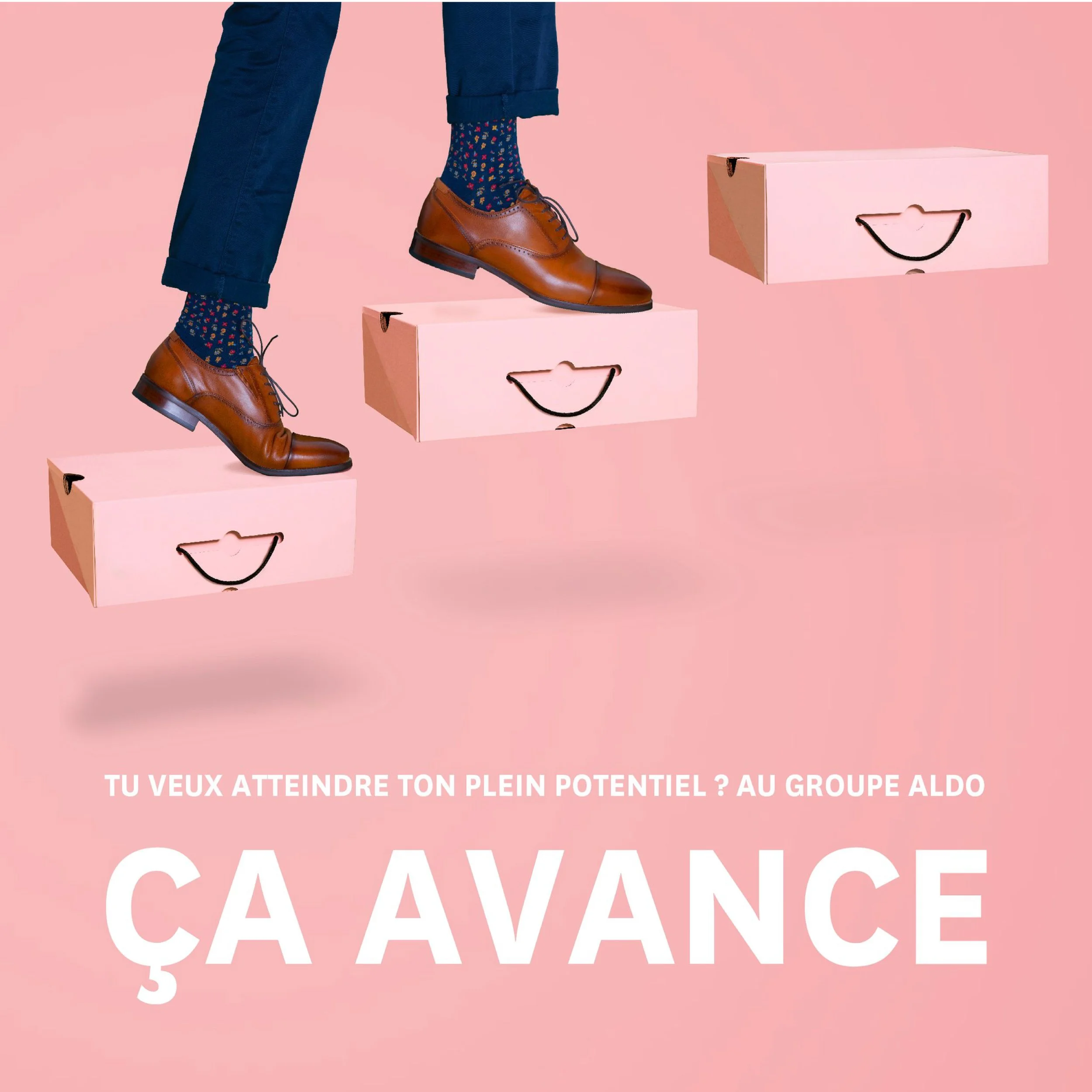 Une personne porte des chaussures en cuir marron, des chaussettes colorées avec des motifs, et un pantalon bleu, debout sur des boîtes roses avec un fond rose. Il y a du texte en français et en anglais sur l'image. Représentant la marque Aldo