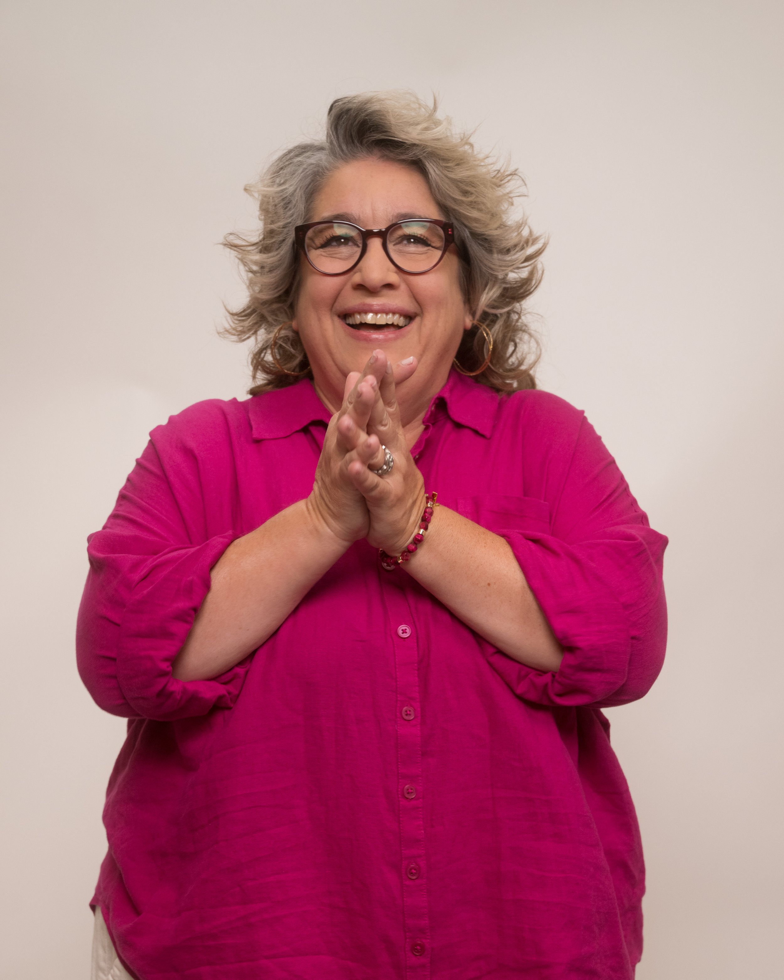Picture of Jen Graybeal in a pink collared shirt, she is looking up and laughing