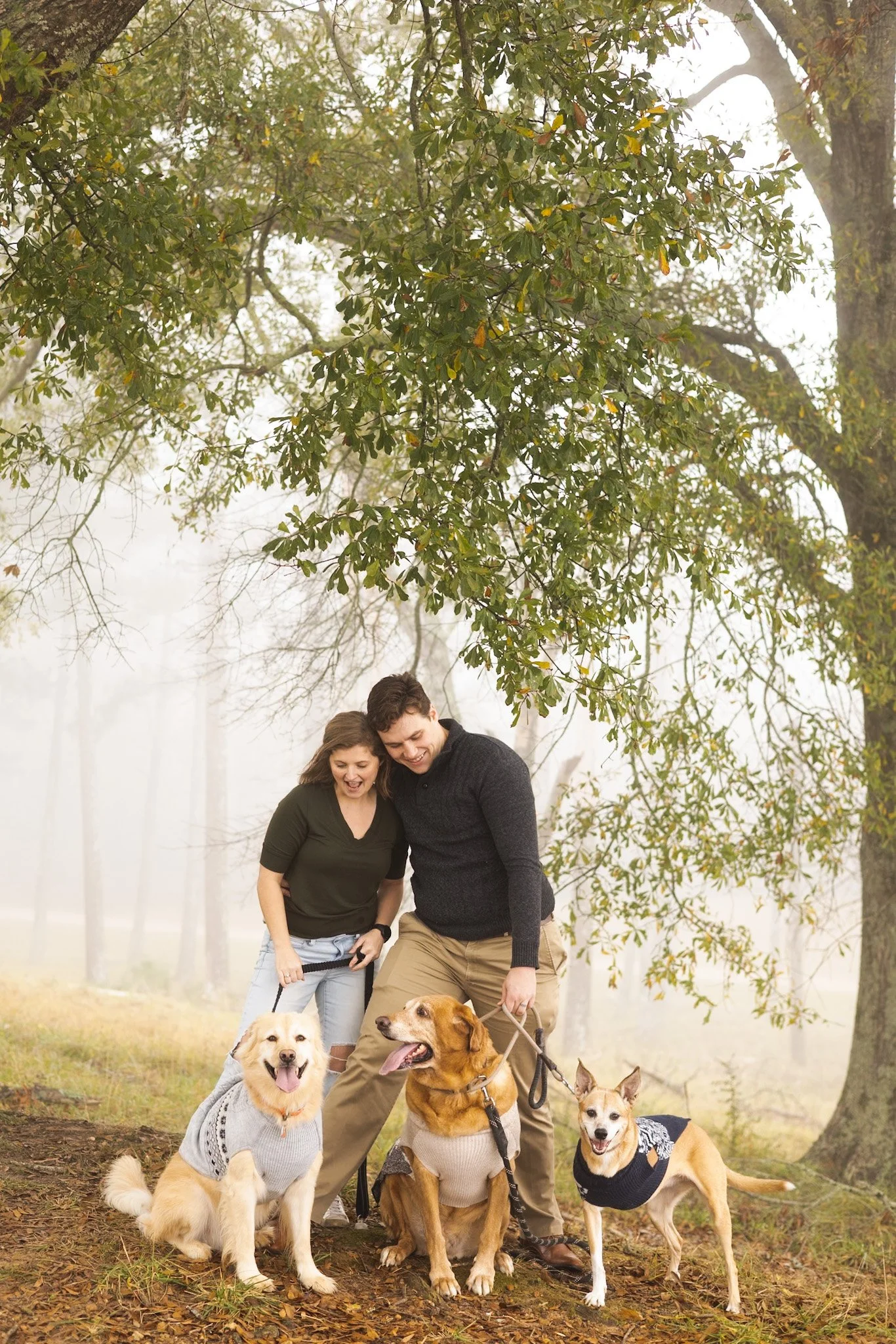A woman crying and wiping her face with a tissue, sitting on a couch during a therapy session with a therapist taking notes, while a young man sits with hands clasped next to her in a living room setting.