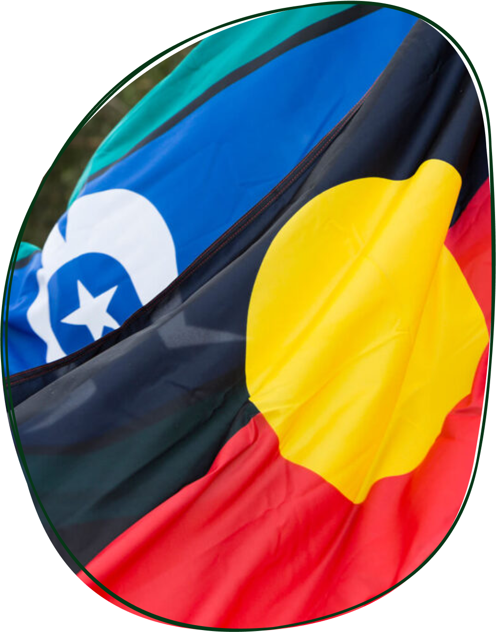 Close-up of a flag featuring the colors and symbols of Australia, with a blue section and a yellow sun symbol, partially overlapping a section with the flag of Tasmania, including a white star and blue background.